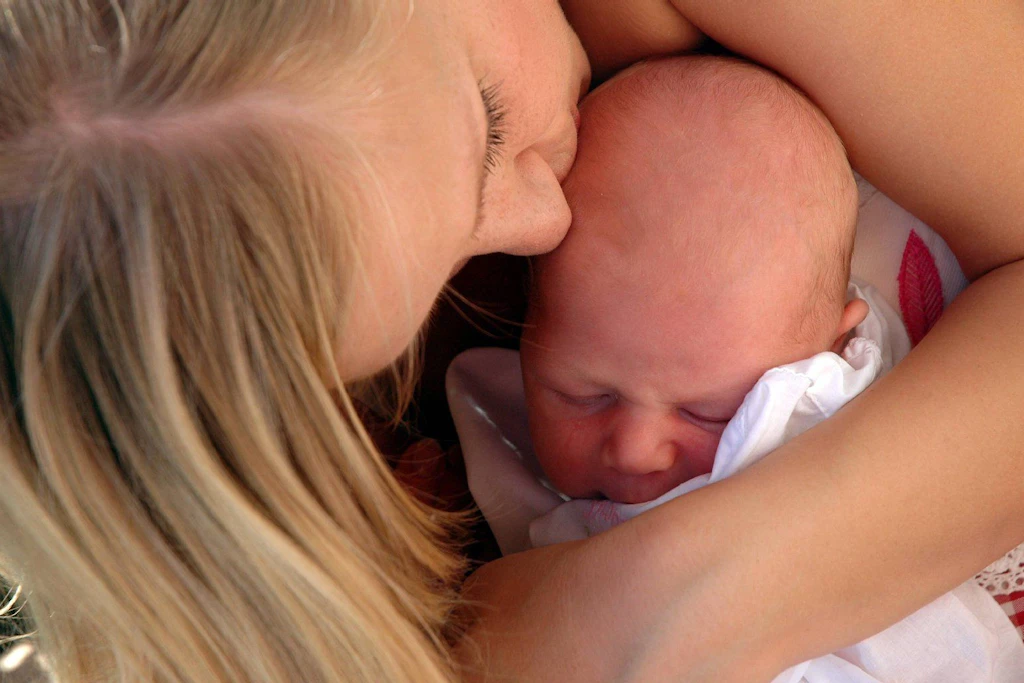 Eine Mutter kuschelt mit ihrem Baby. Ein Babyblues ist nicht schlimm, eine Wochenbettdepression behandlungsbedürftig.