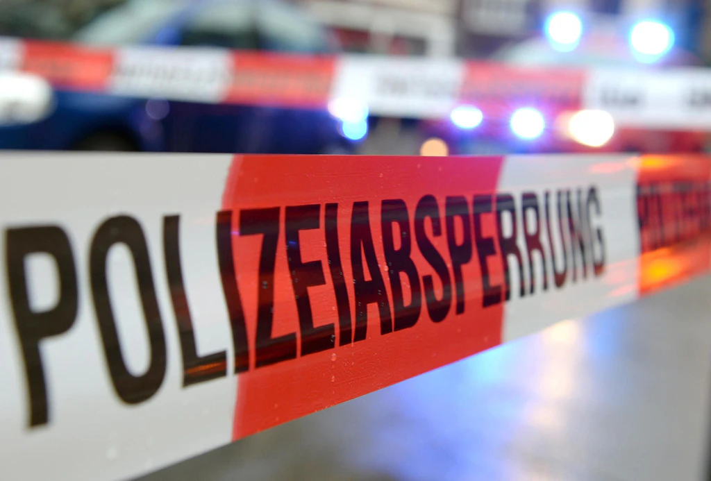 Absperrband der Polizei, dahinter Einsatzwagen