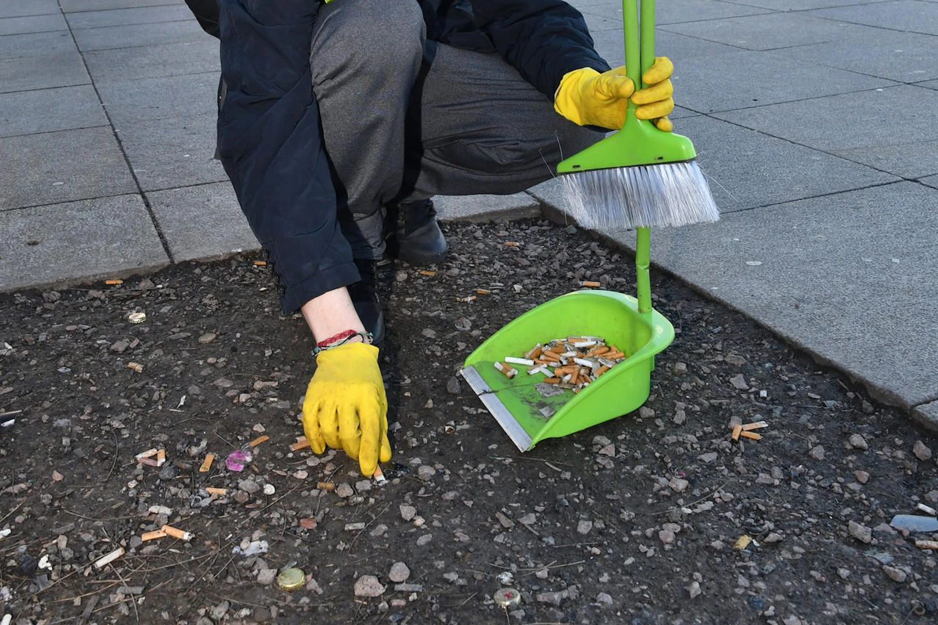 Auf dem Alexanderplatz werden achtlos weggeworfene Zigarettenstummel eingesammelt.