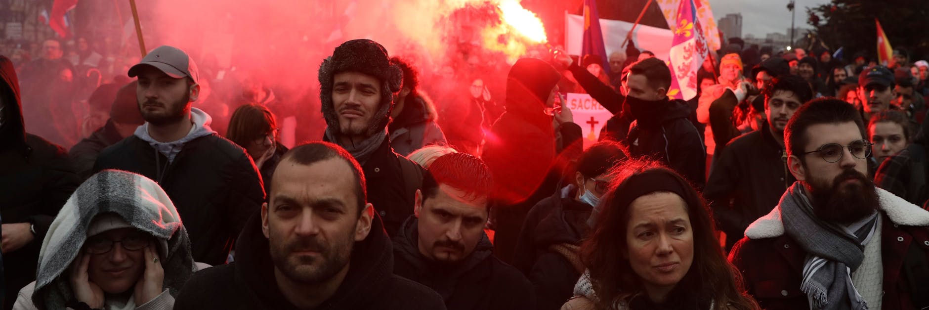 Paris: Teilnehmer an einer Demonstration gegen die Corona-Maßnahmen der Regierung halten Fahnen und Pyrotechnik hoch.