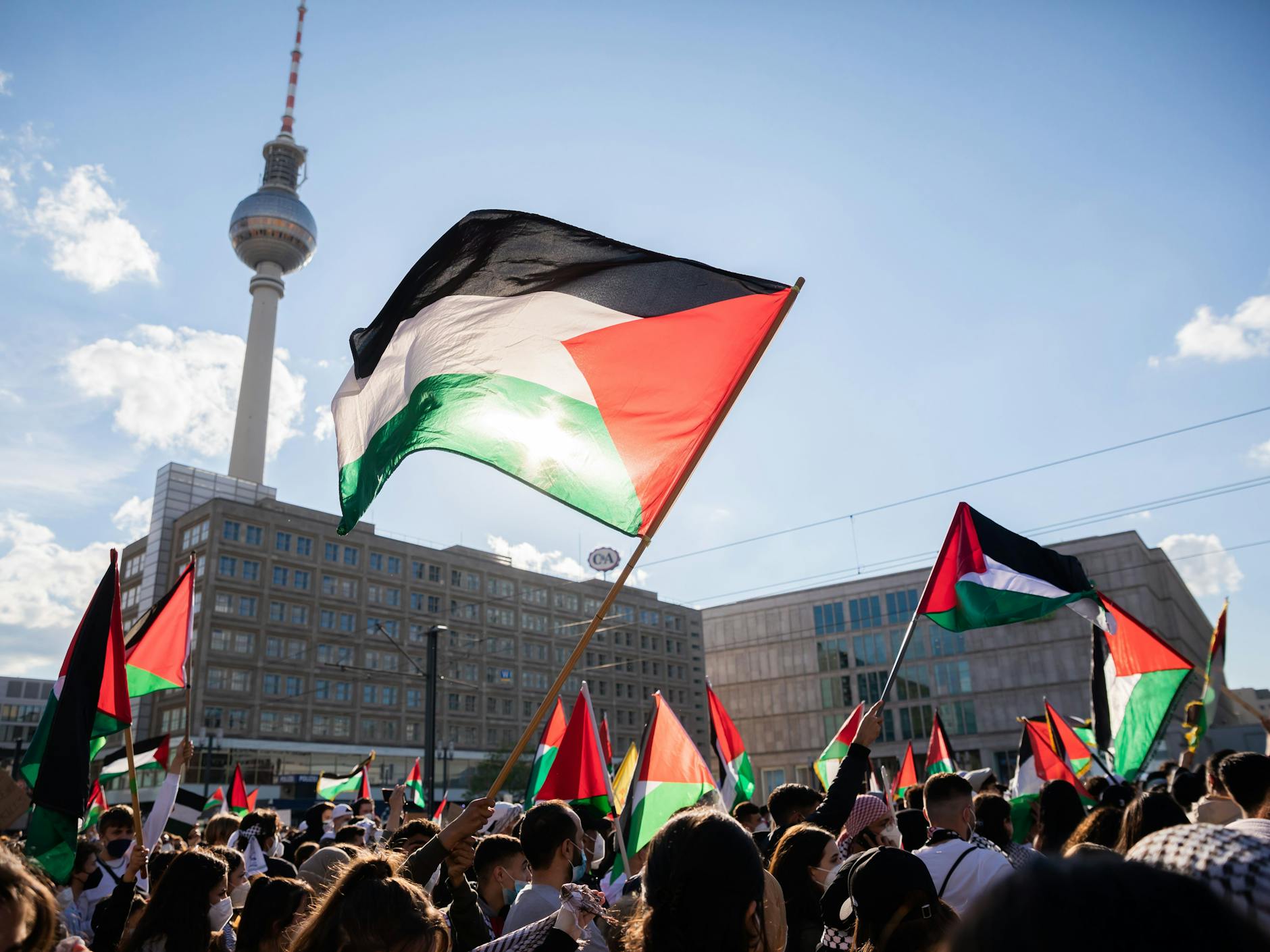 Teilnehmer einer Demonstration unter dem Motto „Gegen die israelische Aggression in Palästina“ haben sich mit Fahnen auf dem Alexanderplatz versammelt.