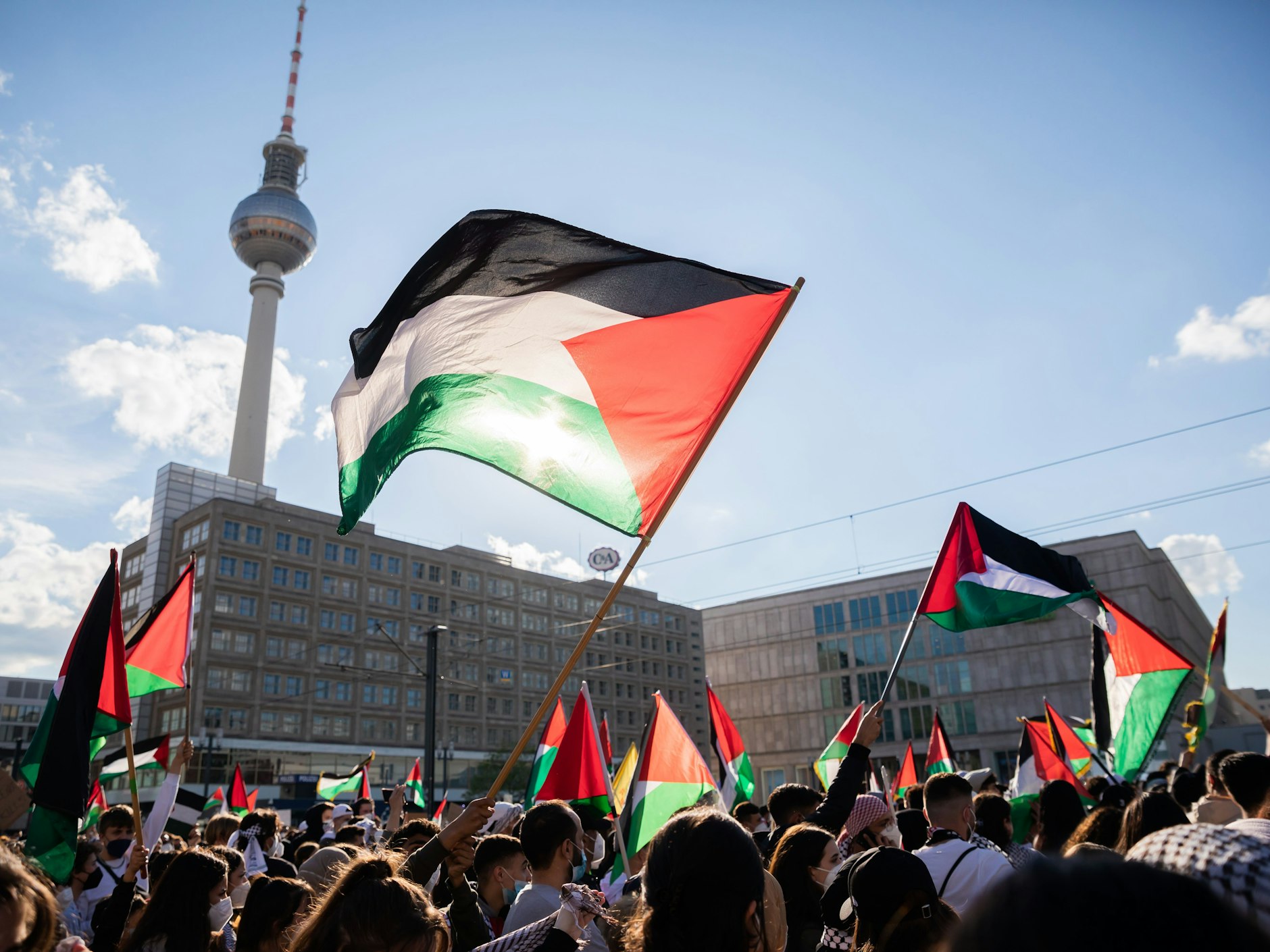 Teilnehmer einer Demonstration unter dem Motto „Gegen die israelische Aggression in Palästina“ haben sich mit Fahnen auf dem Alexanderplatz versammelt.