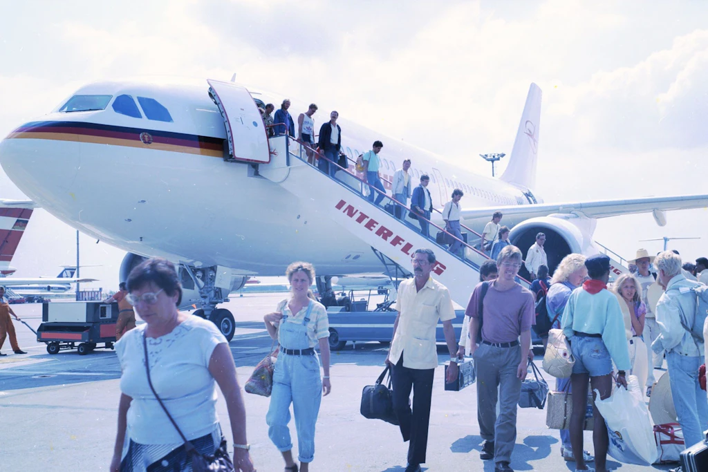 Ein Airbus der Interflug steht auf dem Rollfeld des Flughafens Berlin-Schönefeld. Diese Passagiere kommen mit dem West-Flugzeug gerade aus den Ferien.