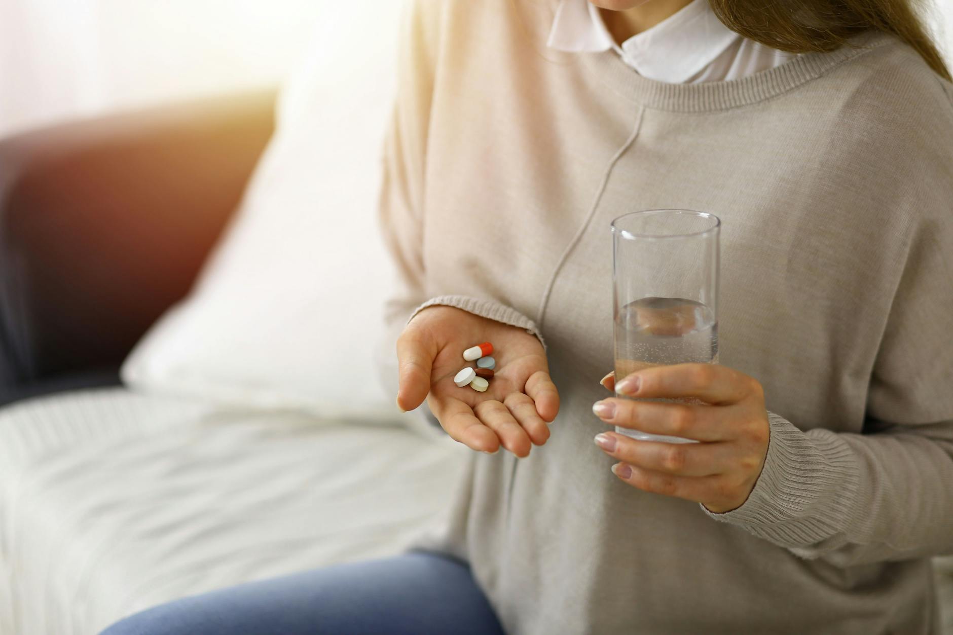 Eine Frau hält Tabletten in der Hand.