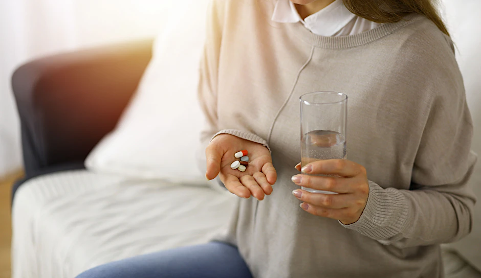 Eine Frau hält Tabletten in der Hand.