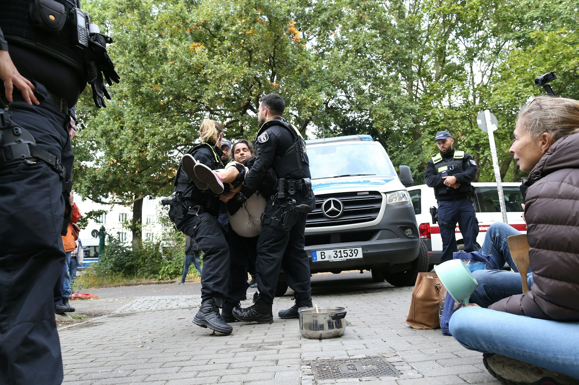 2023: Polizisten tragen eine Demonstrantin aus der Einfahrt, die für die Baumfäller blockiert wurde.