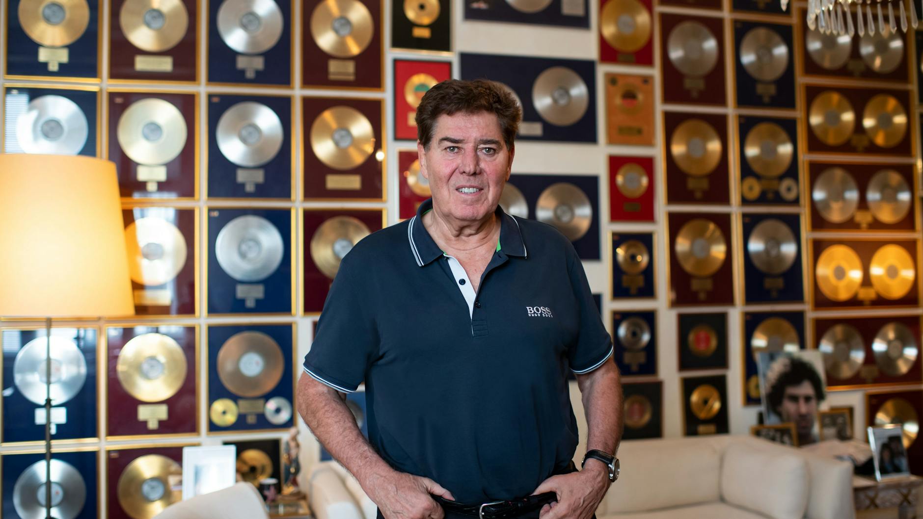 Musikproduzent Jack White steht in seiner Wohnung in Berlin-Charlottenburg, an der Wand hängen zahlreiche Goldene und Platin-Schallplatten.