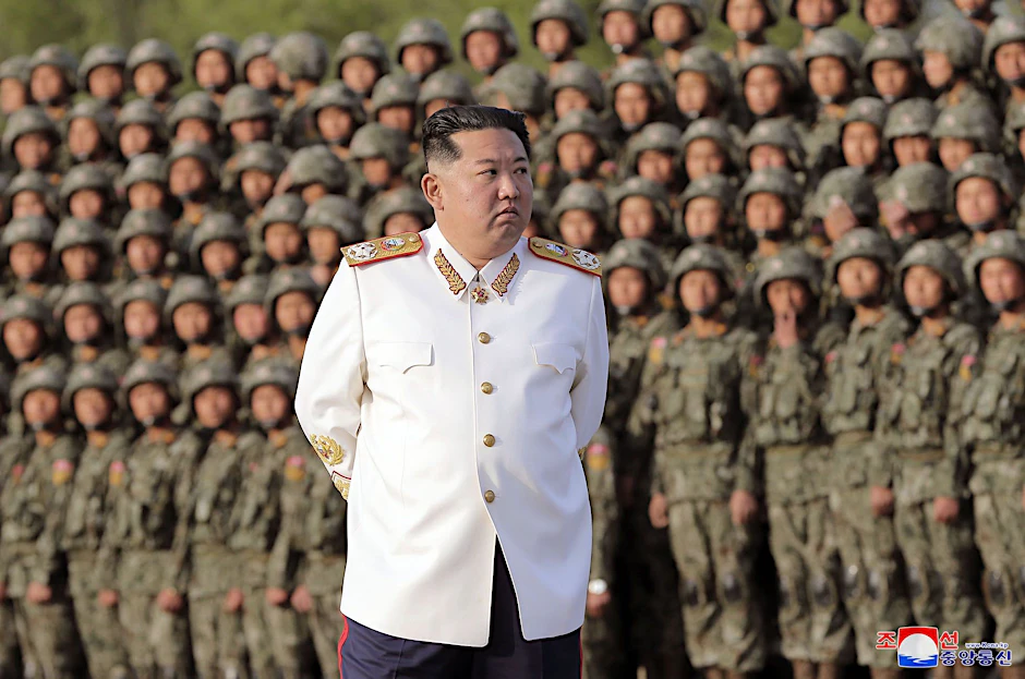 Kim Jong Un, Machthaber von Nordkorea, mit einer weißen Marshal-Uniform vor Soldaten 