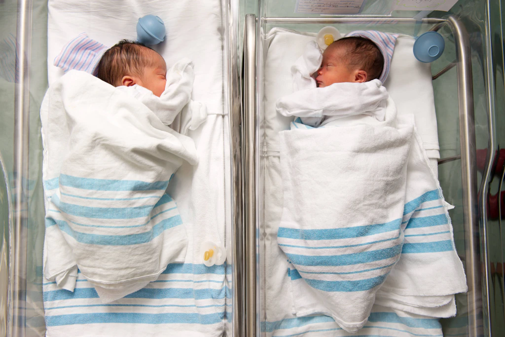Zwei Babys liegen in Krippen im Krankenhaus.