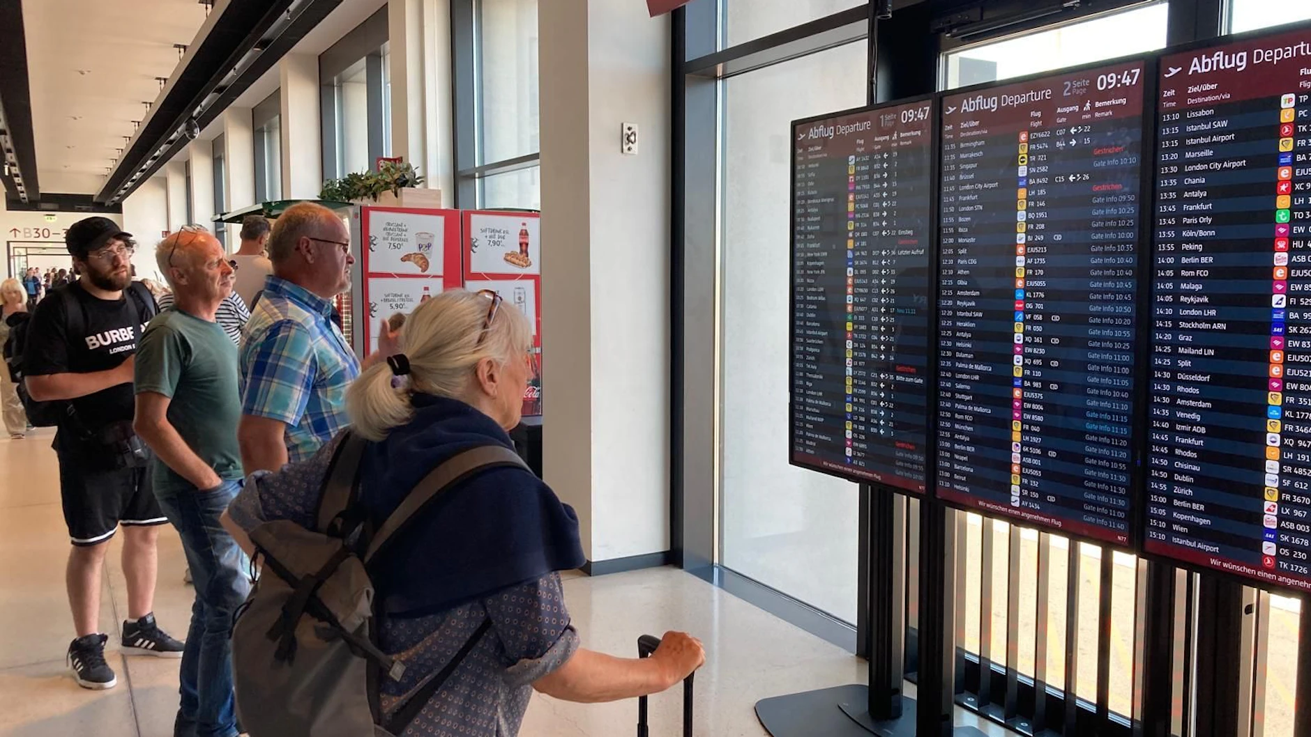 Nichts geht mehr: Gestrandete Passagiere versuchen am BER an den Anzeigetafeln herauszubekommen, wann ihr Flug geht.