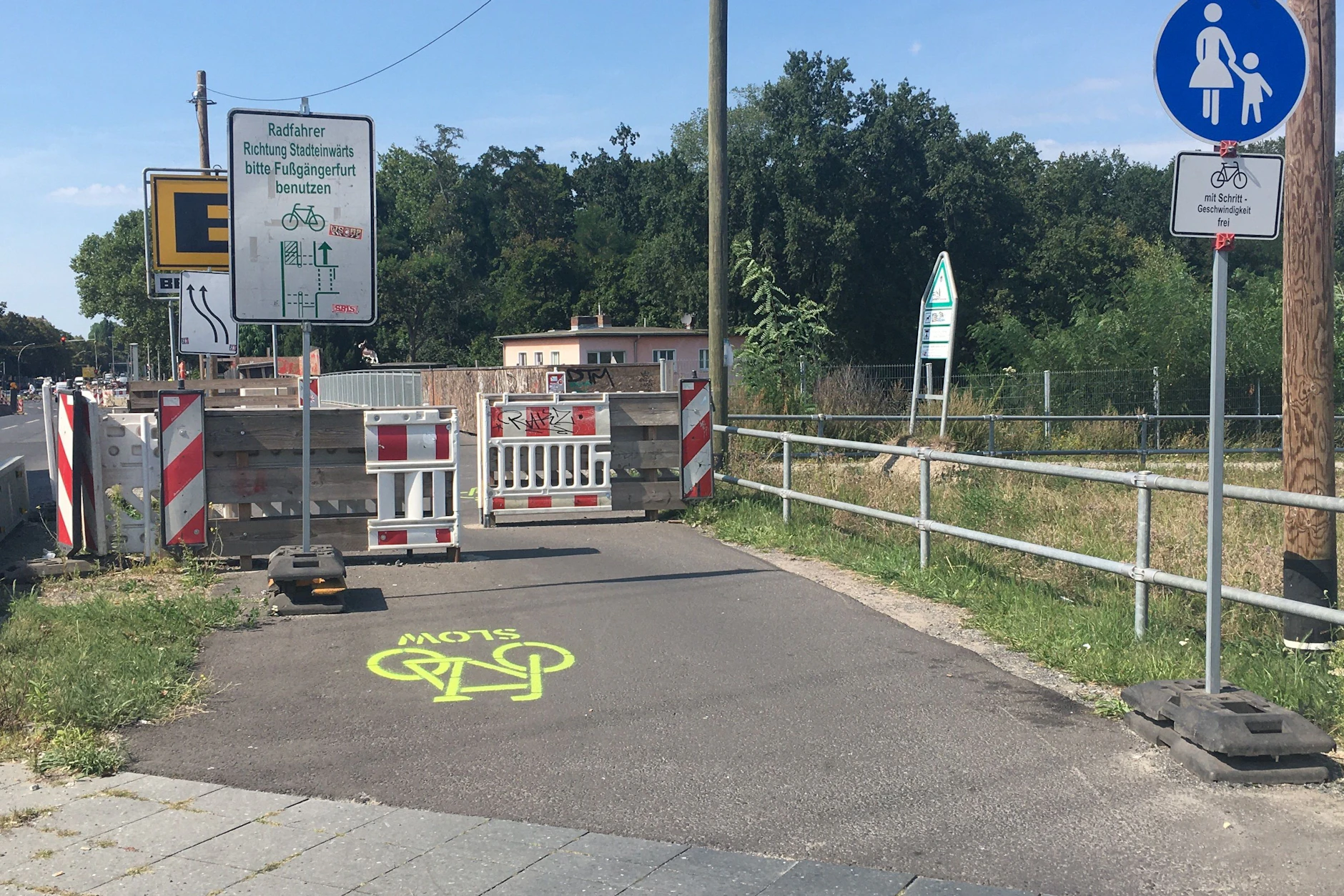 Bitte slow! An der Marggrafenbrücke in Baumschulenweg fordert der Warnhinweis auf Englisch Fahrradfahrer zum Langsamfahren auf.