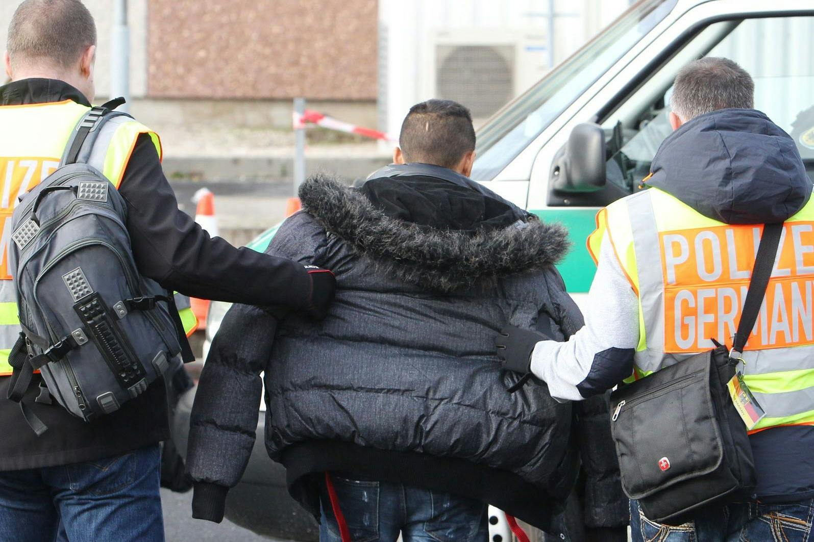 Polizisten begleiten einen straffällig gewordenen Asylbewerber zum Flughafen.