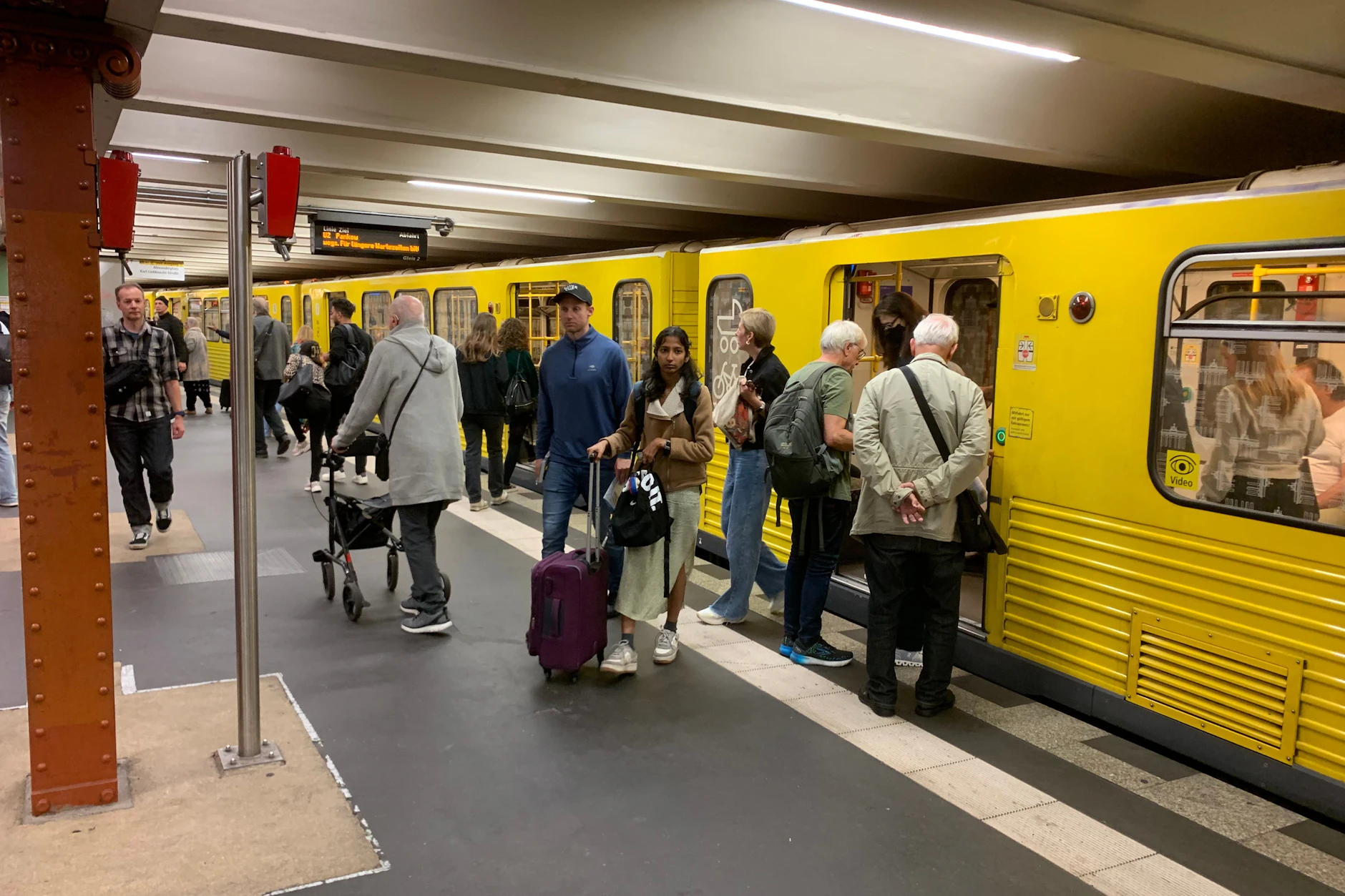 Volle Züge im U-Bahnhof Alexanderplatz: Auf einem Laufband im digitalen Zuganzeiger entschuldigt sich die BVG für längere Wartezeiten auf der U2.