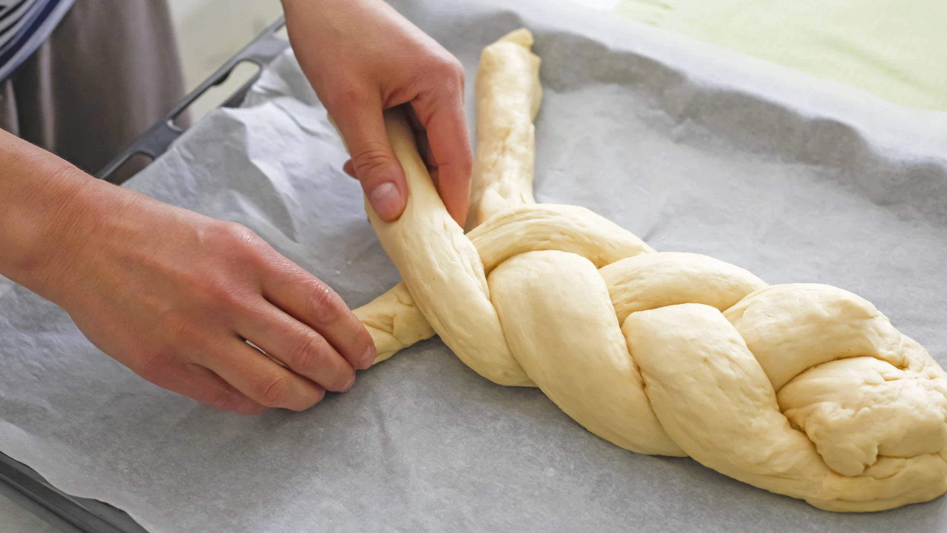 Die drei Stränge werden zum Hefezopf geflochten und die Enden untergehoben.