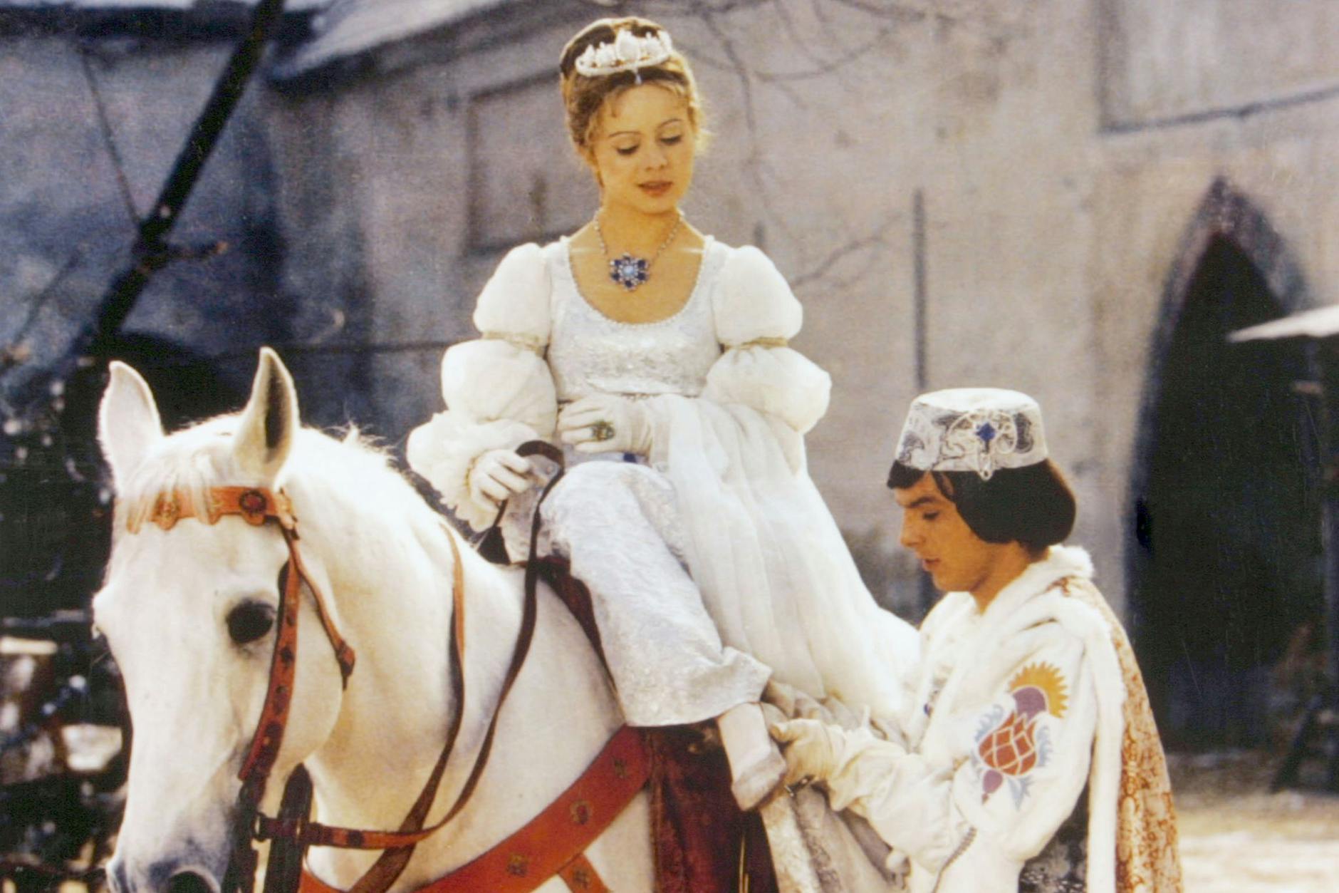 Der Prinz (Pavel Trávnícek) passt Aschenbrödel (Libuse Safránková) den verlorenen Schuh an – eine Szene aus dem Film „Drei Haselnüsse für Aschenbrödel“.