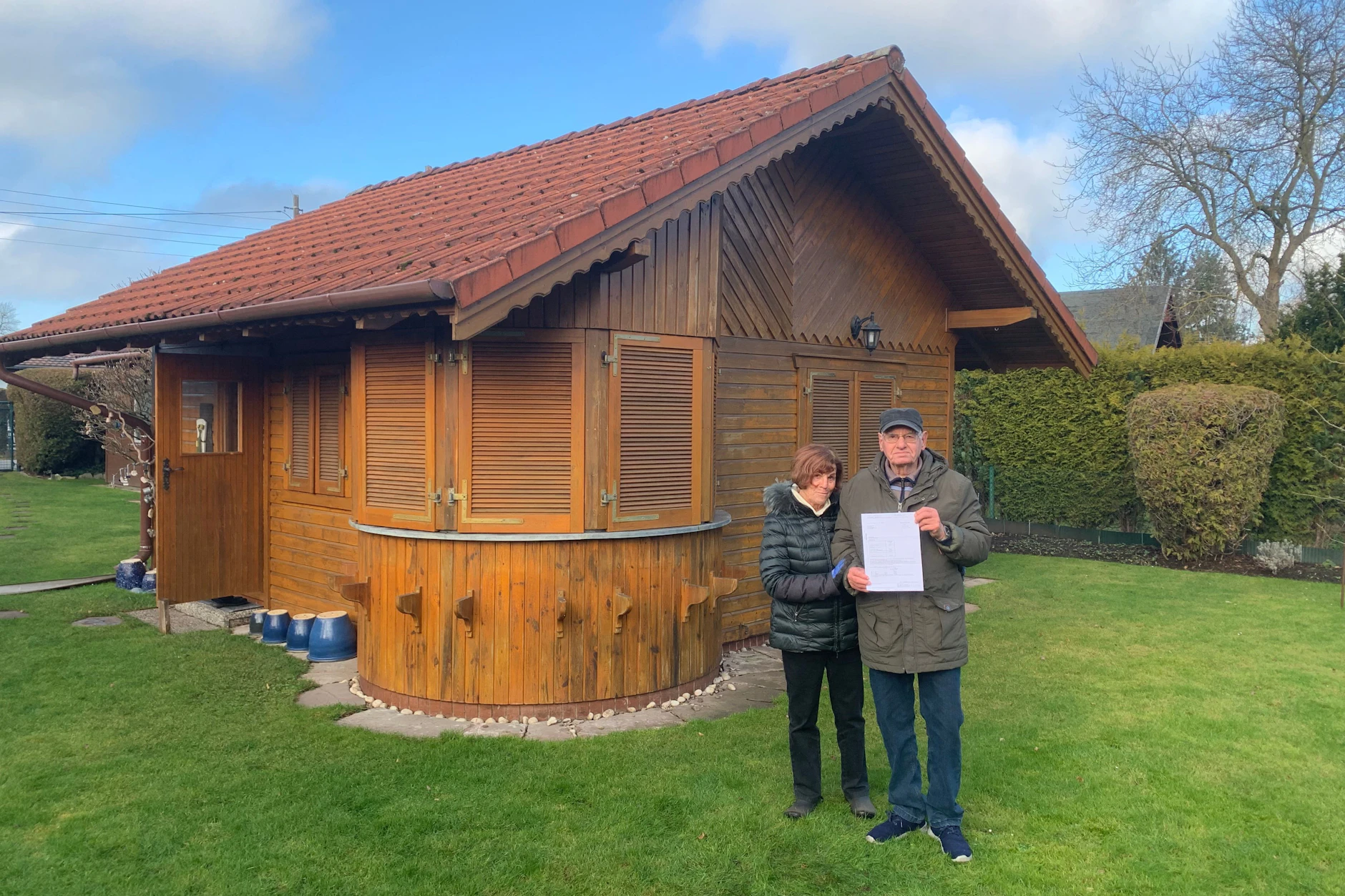 Vor ihrem Wochenendhäuschen: Die Rentner Kristina (81) und Achim Girke (83) mit dem Grundsteuerbescheid. Sie müssen künftig 956 Euro statt 80 Euro im Jahr zahlen.