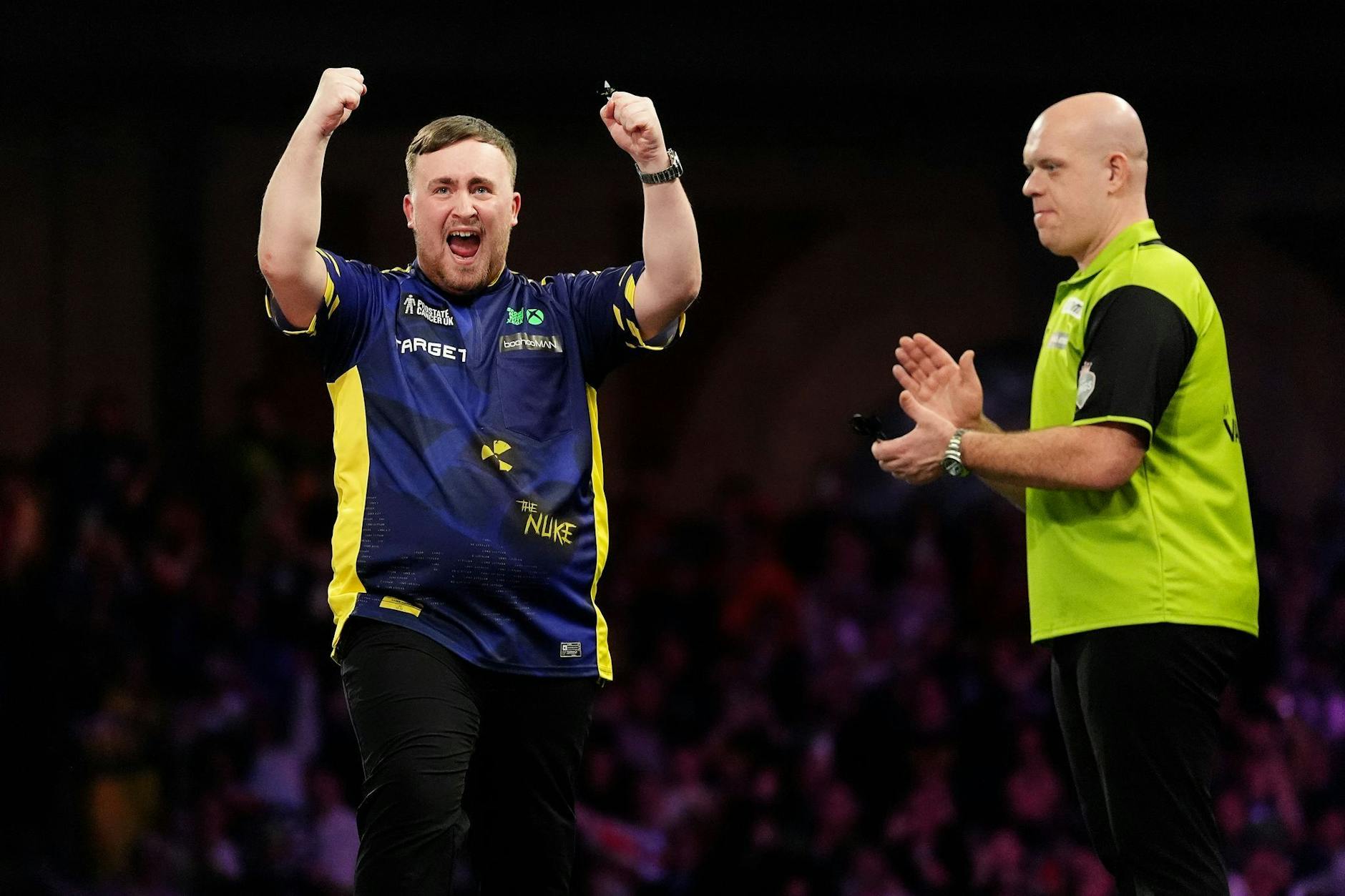 Luke Littler (l.) feiert den Sieg im Finale der Paddy Power World Darts Championship gegen Michael van Gerwen.