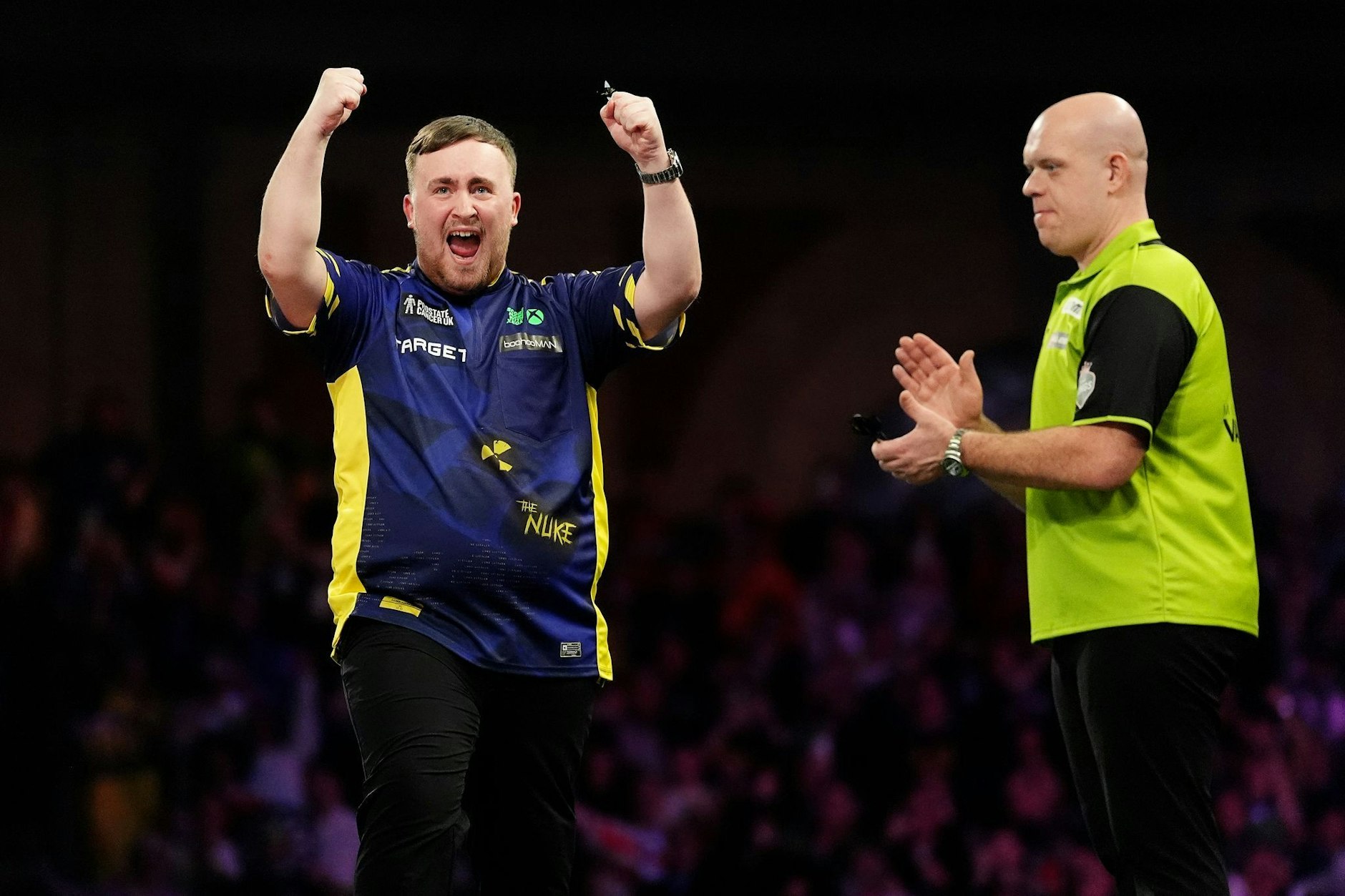 Luke Littler (l.) feiert den Sieg im Finale der Paddy Power World Darts Championship gegen Michael van Gerwen.