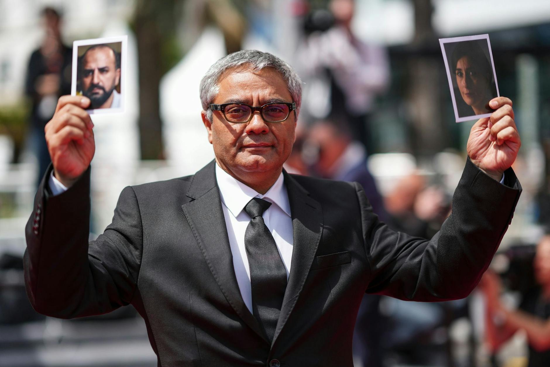 Mohammad Rasoulof im Mai 2024 in Cannes: Gerade erst aus dem Iran geflohen, zeigt er die Bilder von zwei Mitgliedern seines Ensembles aus dem Film „Die Saat des heiligen Feigenbaums“, die nicht ausreisen konnten.