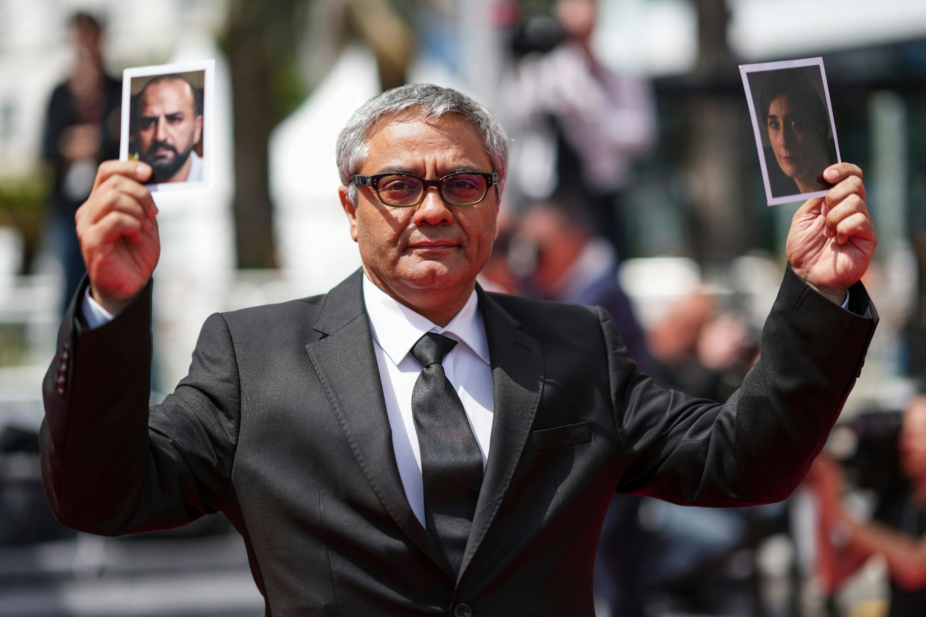 Mohammad Rasoulof im Mai 2024 in Cannes: Gerade erst aus dem Iran geflohen, zeigt er die Bilder von zwei Mitgliedern seines Ensembles aus dem Film „Die Saat des heiligen Feigenbaums“, die nicht ausreisen konnten.