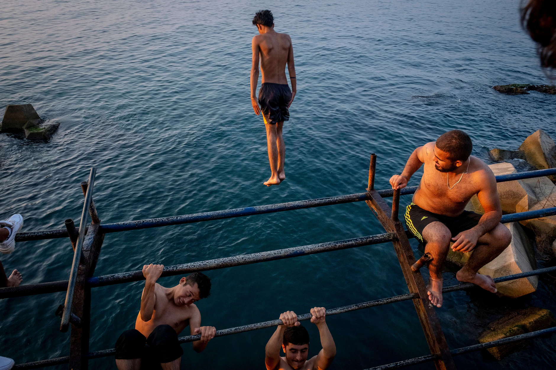 Junge Männer springen an der Corniche in Beirut ins Wasser.