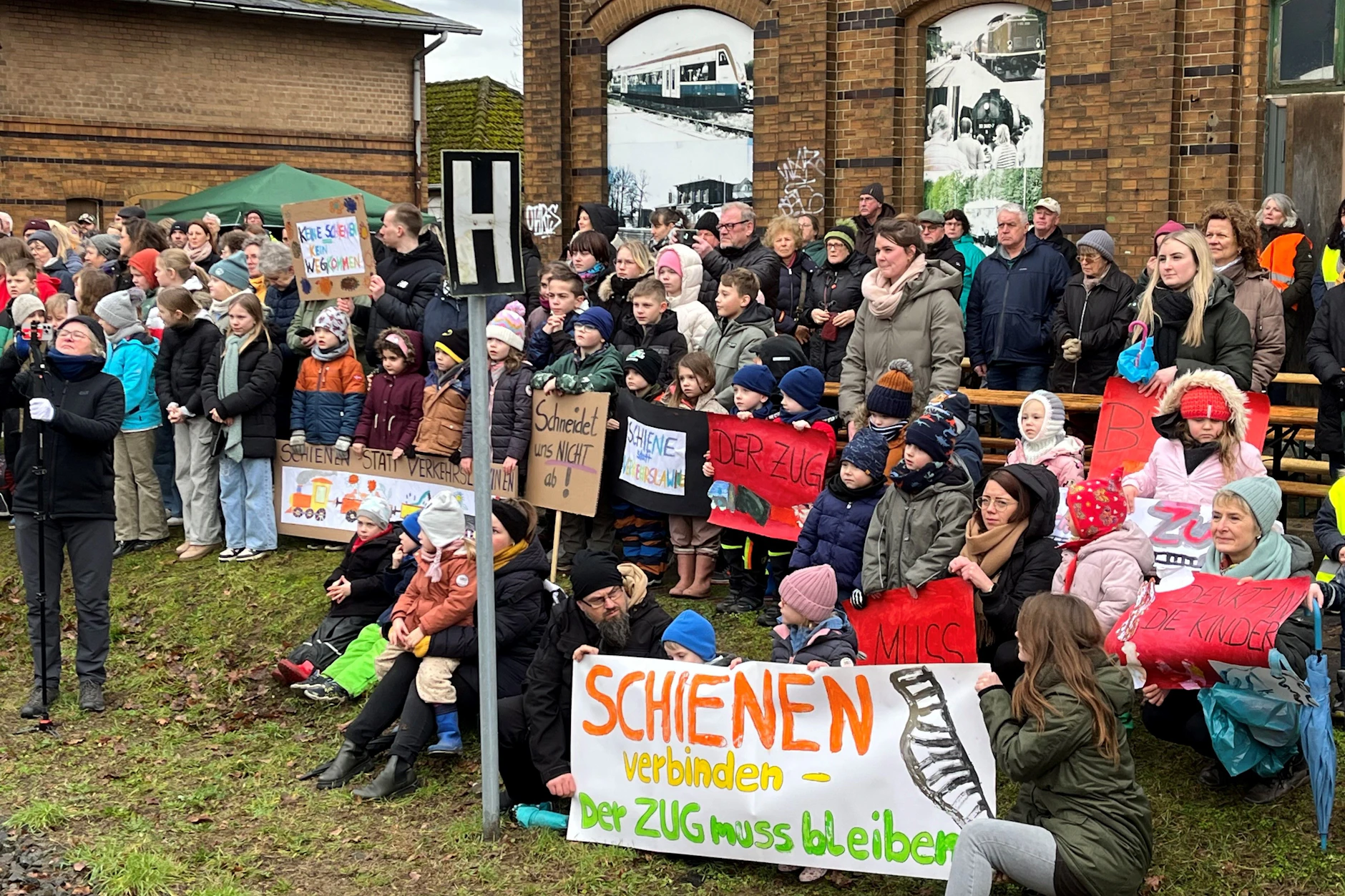 Am Bahnhof Meyenburg in der Prignitz demonstrieren Bürger 2025 für die Verbesserung des Bahnverkehrs. Bald könnte für mehr Züge und die Reaktivierung von Strecken Geld fehlen.