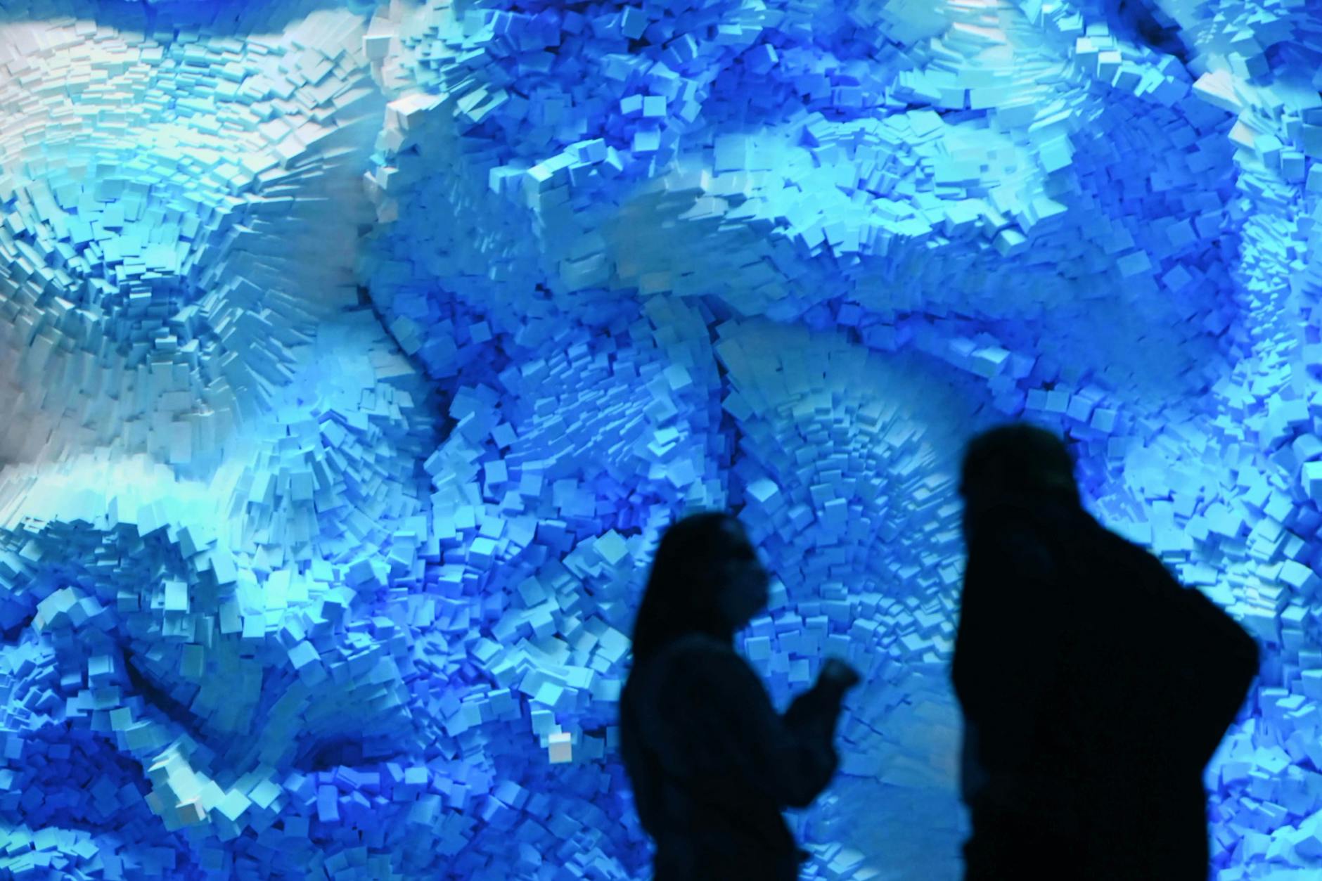 Besucher im Kurhaus Baden-Baden vor einem Kunstwerk Refik Anadols, in dessen Werken KI eine prominente Rolle spielt.