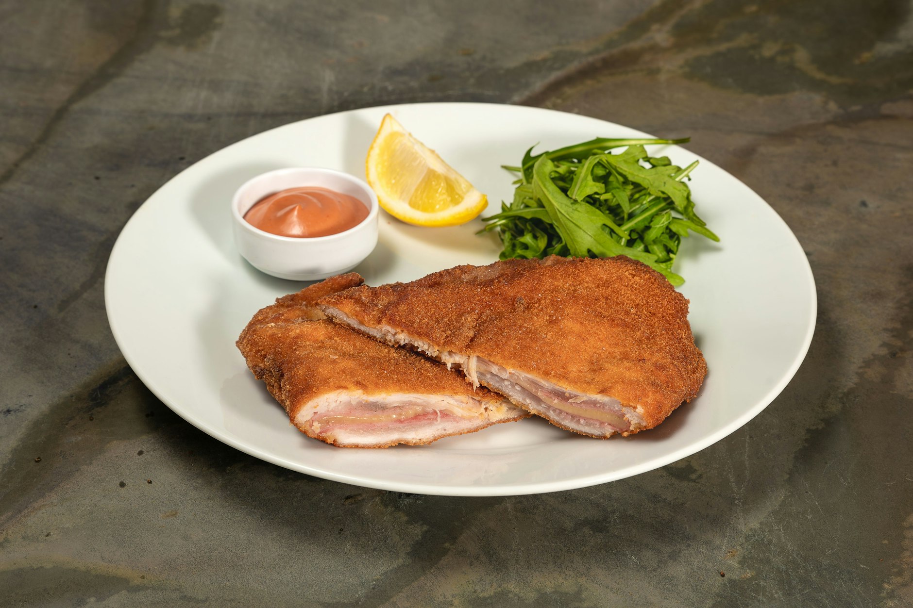 Ein Cordon bleu, geteilt in zwei Hälften – gefüllt mit Käse und Kochschinken.