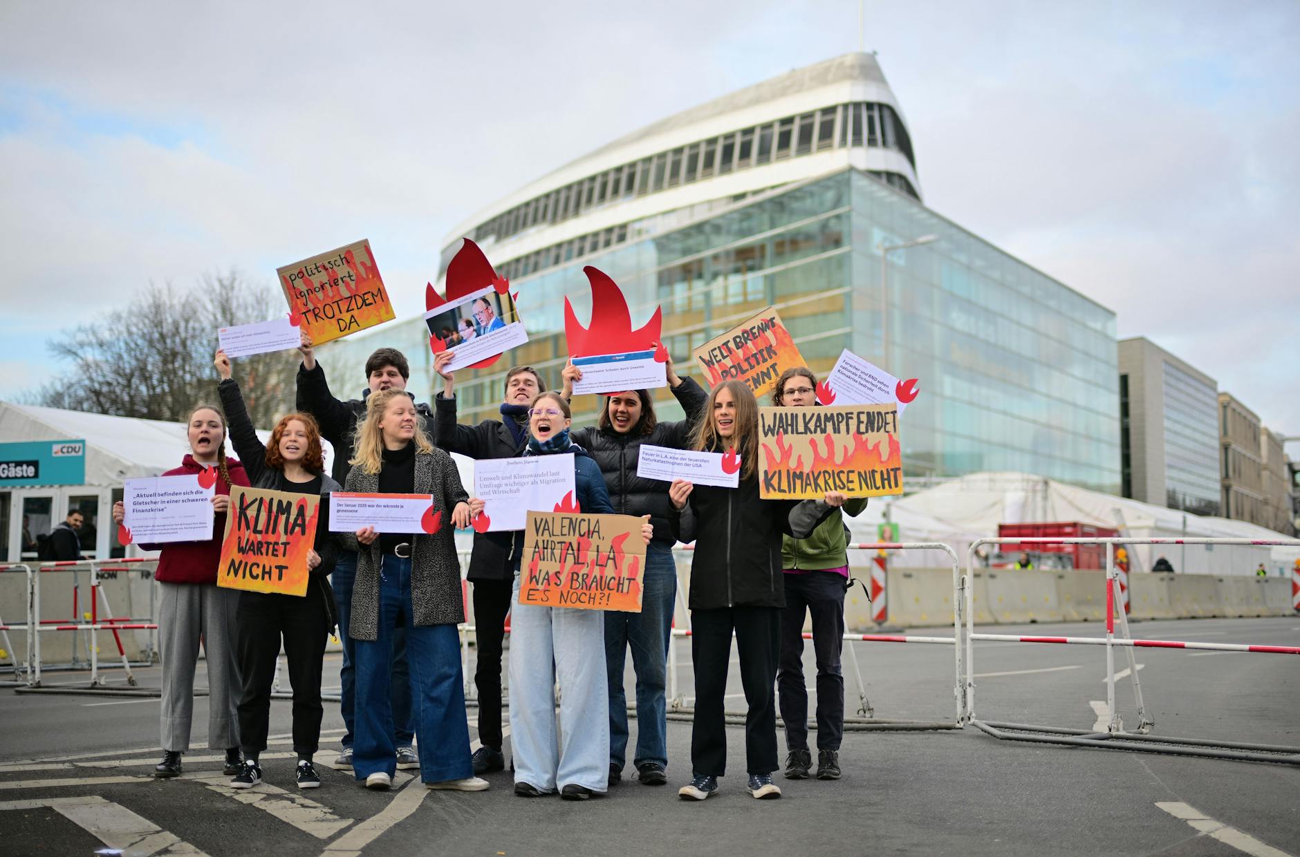Demonstrierende von Fridays for Future stehen vor der CDU-Bundesgeschäftsstelle und halten Plakate, darunter mit der Aufschrift "Wahlkampf endet Klimakrise nicht"
