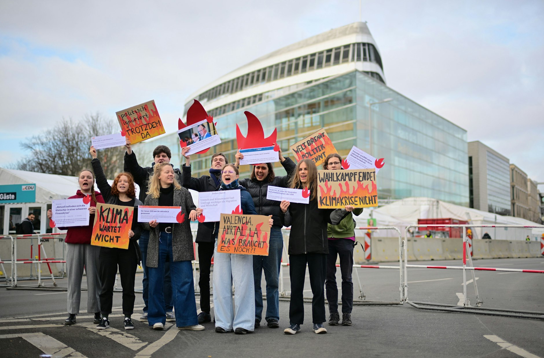 Demonstrierende von Fridays for Future stehen vor der CDU-Bundesgeschäftsstelle und halten Plakate, darunter mit der Aufschrift "Wahlkampf endet Klimakrise nicht"
