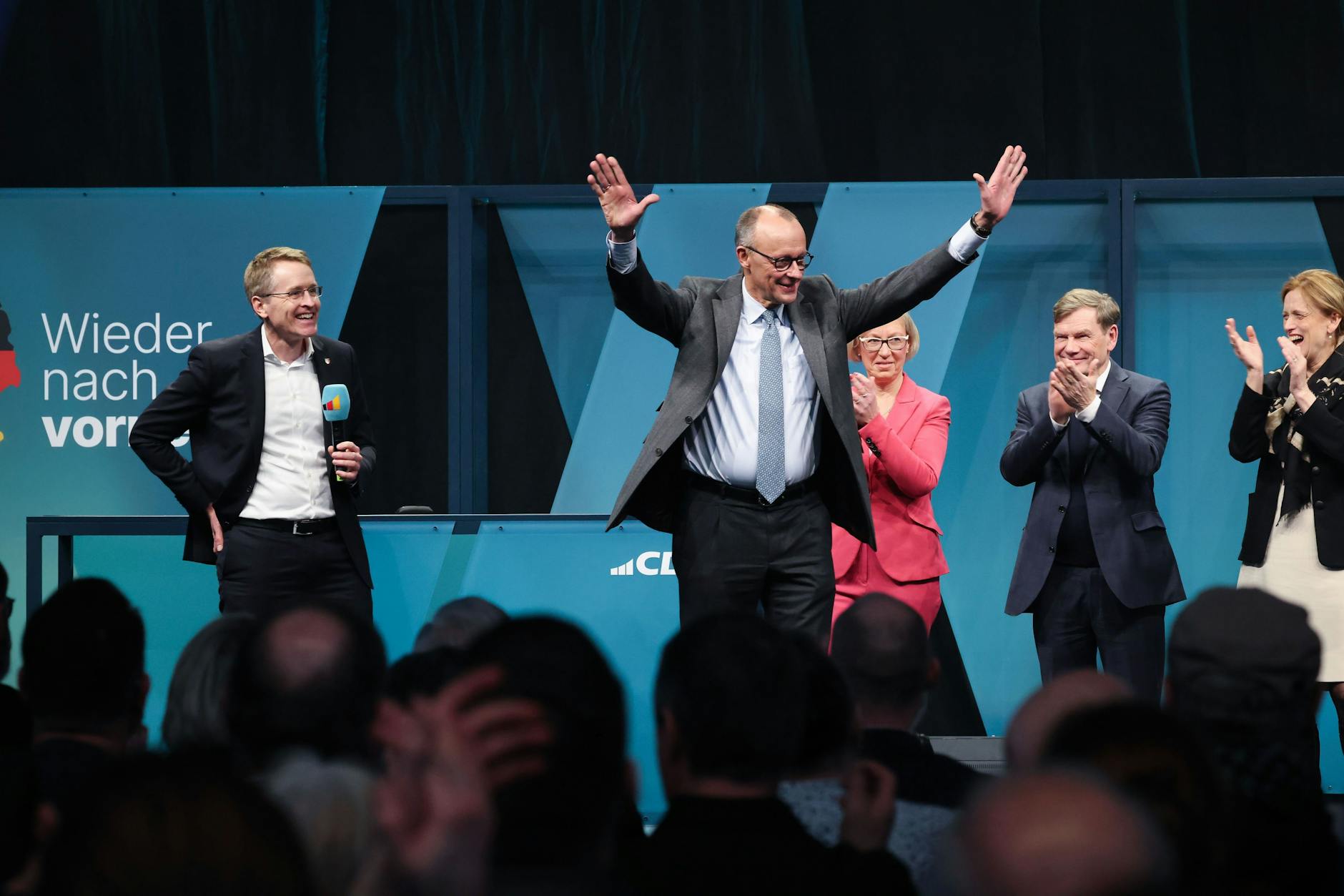 Hinter Wahlsieger Friedrich Merz bei dieser Wahlveranstaltung in Flensburg steht im roten Blazer CDU-Wahlkreisgewinnerin Petra Nicolaisen. Sie wird dennoch nicht in den Bundestag einziehen.
