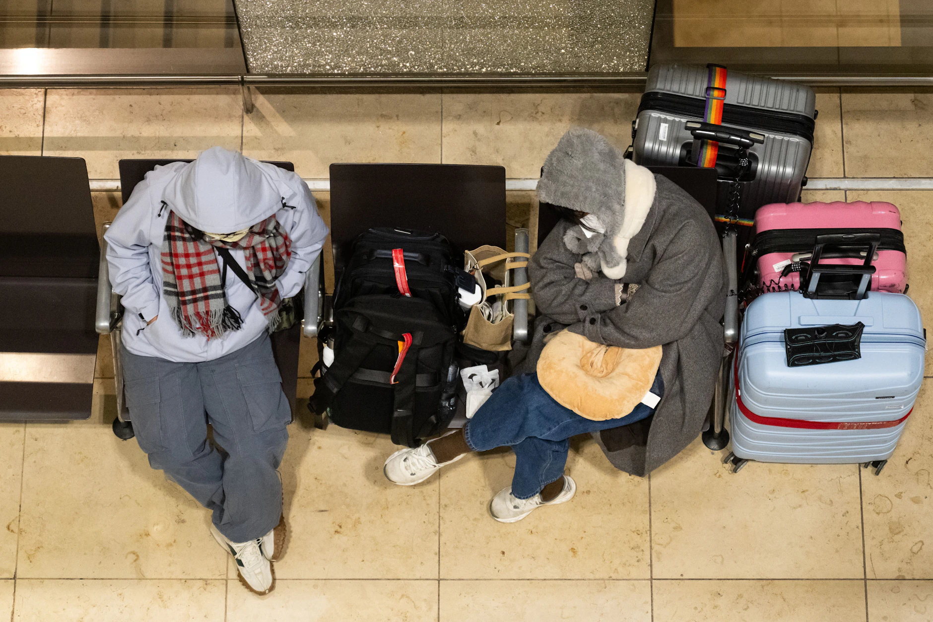 Zwei gestrandete Reisende sitzen am Montagmorgen am Flughafen Berlin Brandenburg BER mit ihrem Gepäck im Terminal. Die Gewerkschaft Verdi hat die Beschäftigten des öffentlichen Dienstes und der Bodenverkehrsdienste für Montag zu einem 24-stündigen Warnstreik an 13 Flughäfen aufgerufen. 