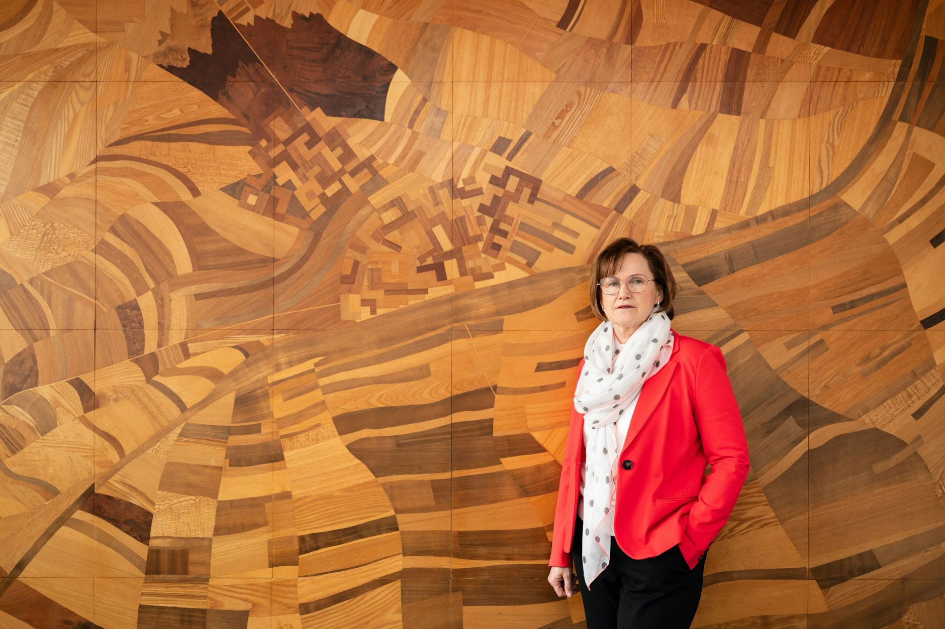 Annekathrin Hoppe (SPD) vor einem Holzmosaik mit der abstrakten Abbildung von Schwedt