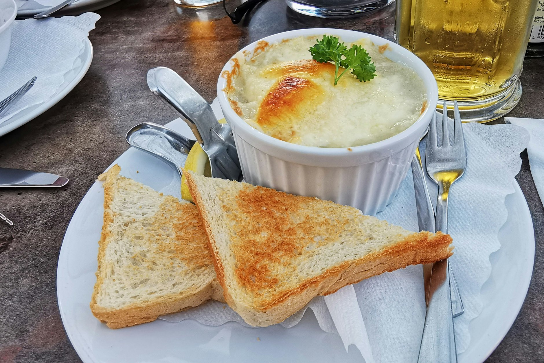 Ragout fin, in einer hitzebeständigen Form überbacken, serviert ganz klassisch mit Toastbrot