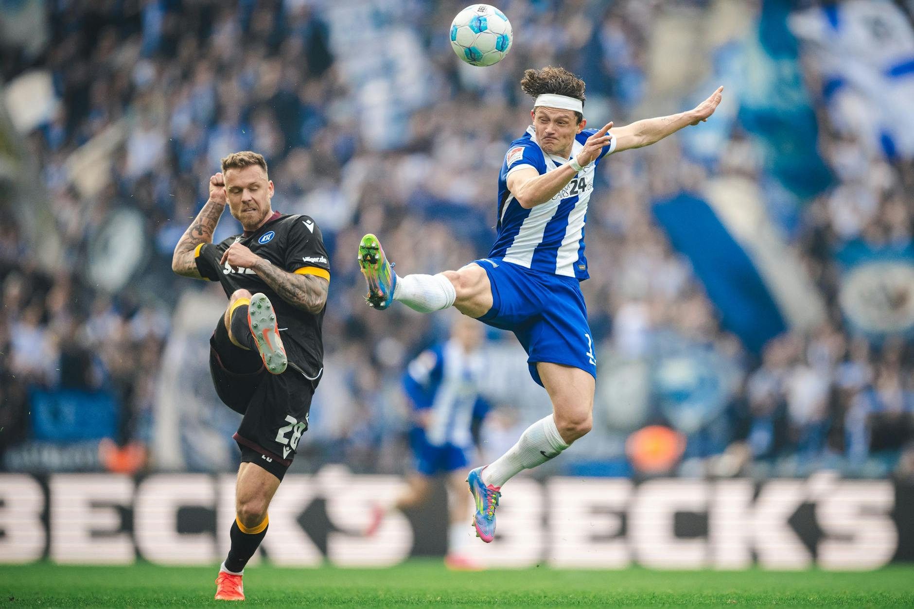 Hertha-Angreifer Fabian Reese setzt sich akrobatisch gegen den Karlsruher Marcel Franke durch.