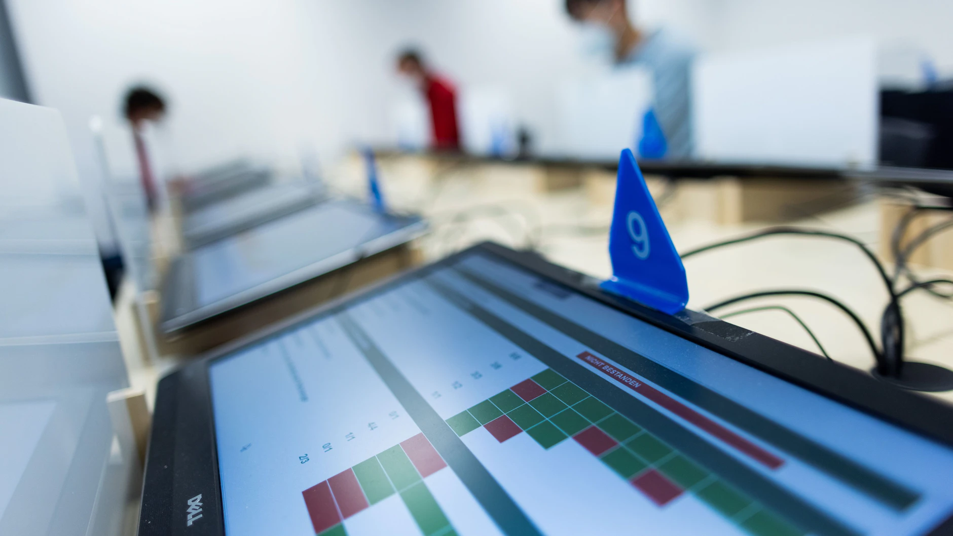 „Nicht bestanden“ steht auf dem Monitor eines Prüfers bei der theoretischen Prüfung für den Führerschein beim TÜV-Rheinland, während im Hintergrund Prüflinge die Aufgaben absolvieren.