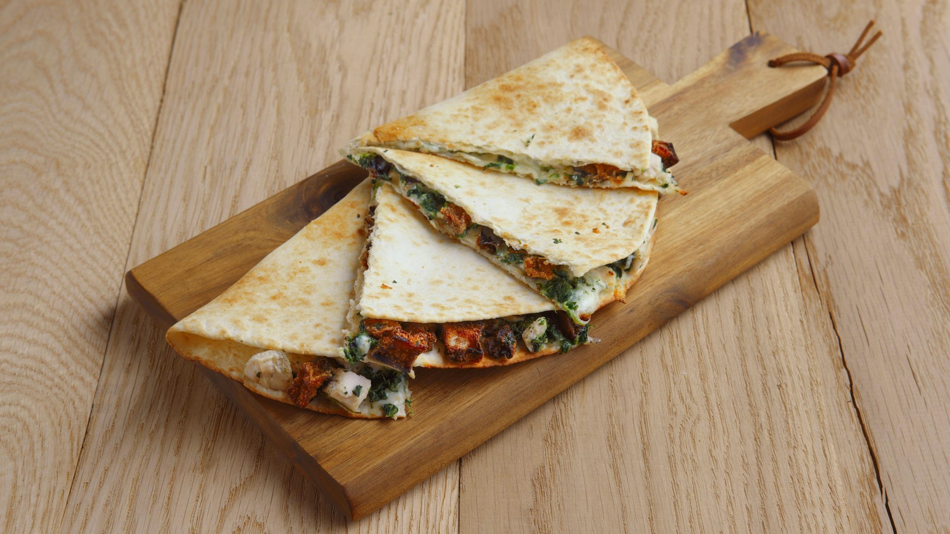 Zum Schluss werden die Quesadillas auf dem Schneidebrett geviertelt.