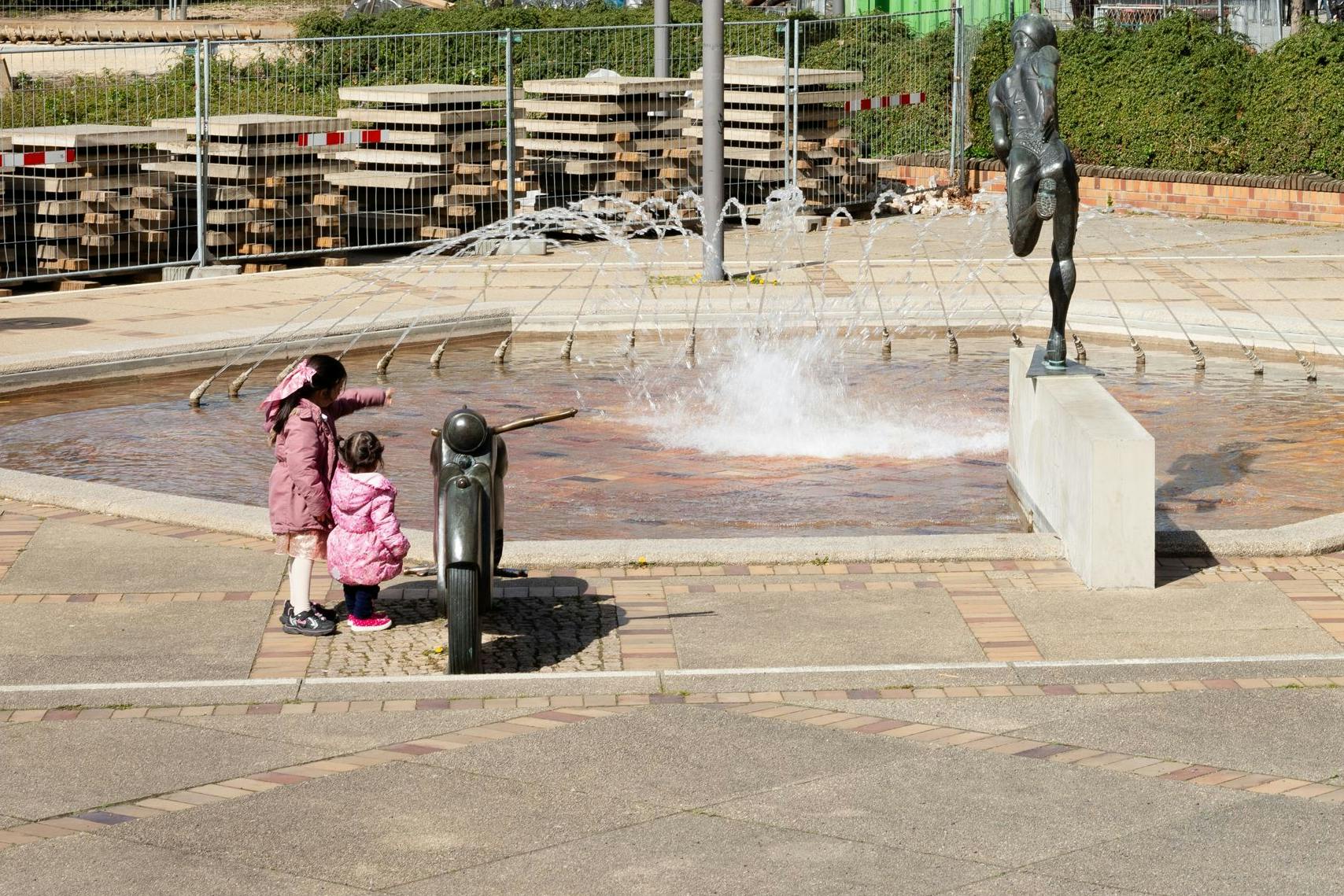 Motorrad, Sportler, Wasserspiele: der Brunnen vor dem Rathaus