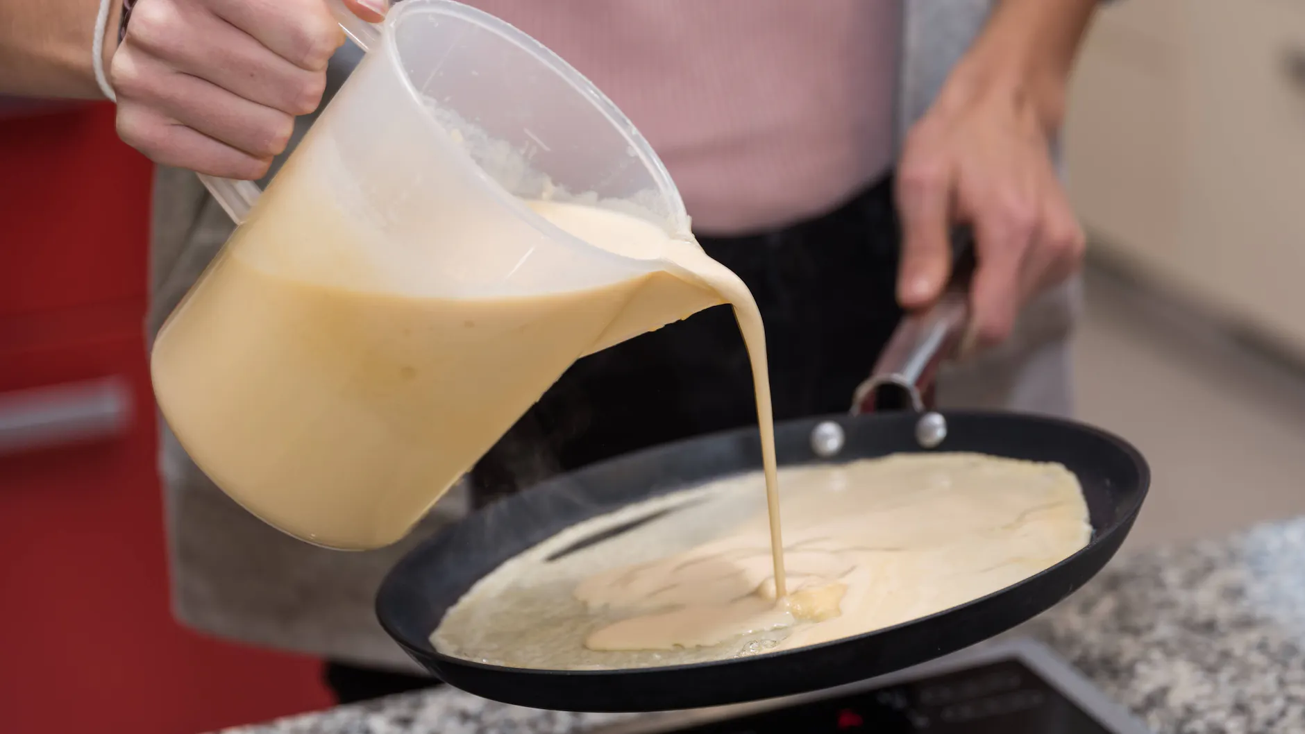 Mit einem Messbecher wird die gewünschte Menge Teig in eine Pfanne (mittlere Hitze) gegeben.