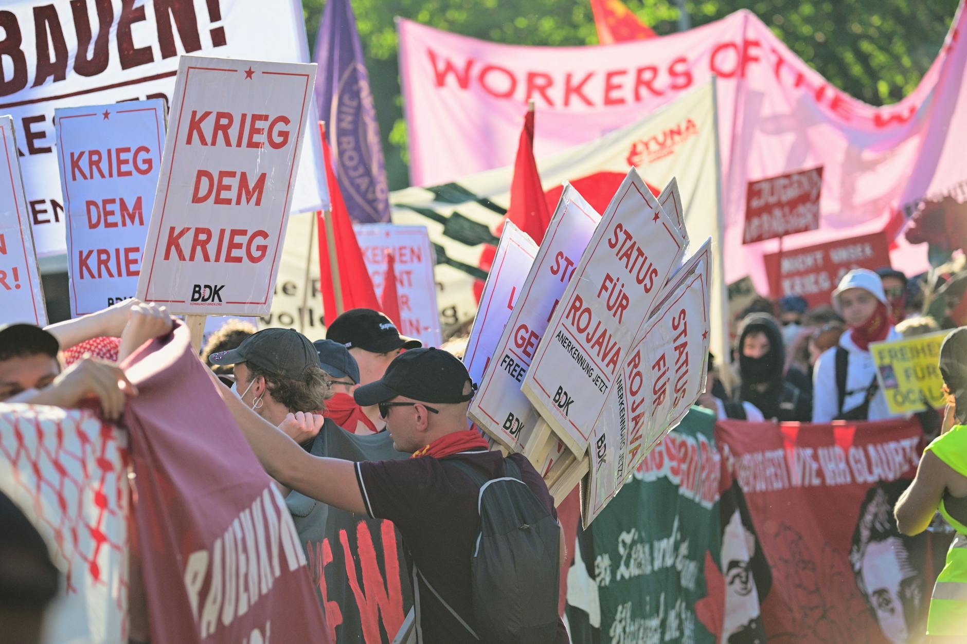 Ein Mann verteilt vor der revolutionären 1. Mai-Demo Schilder unter anderem mit der Aufschrift «Krieg dem Krieg» im ersten Block.