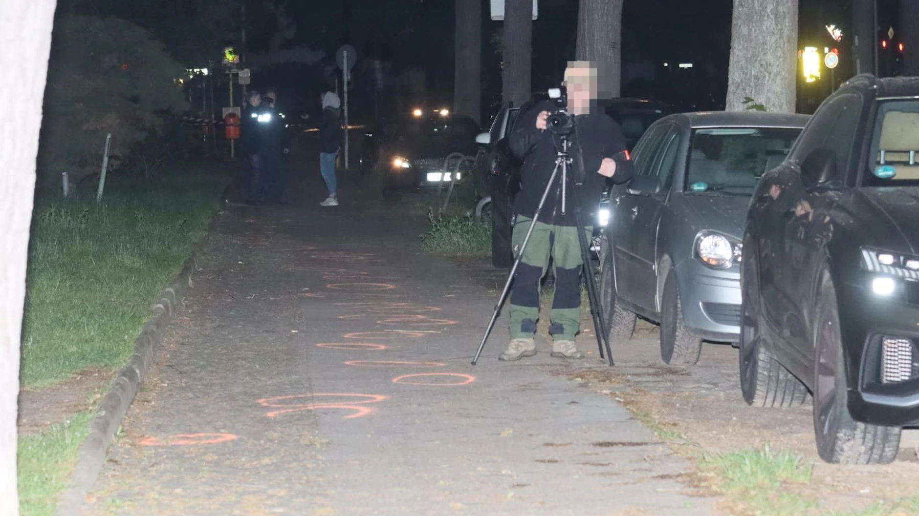 Die Spurensicherung bei der Arbeit. Auf dem Gehweg eingekreist sind die Blutspuren.