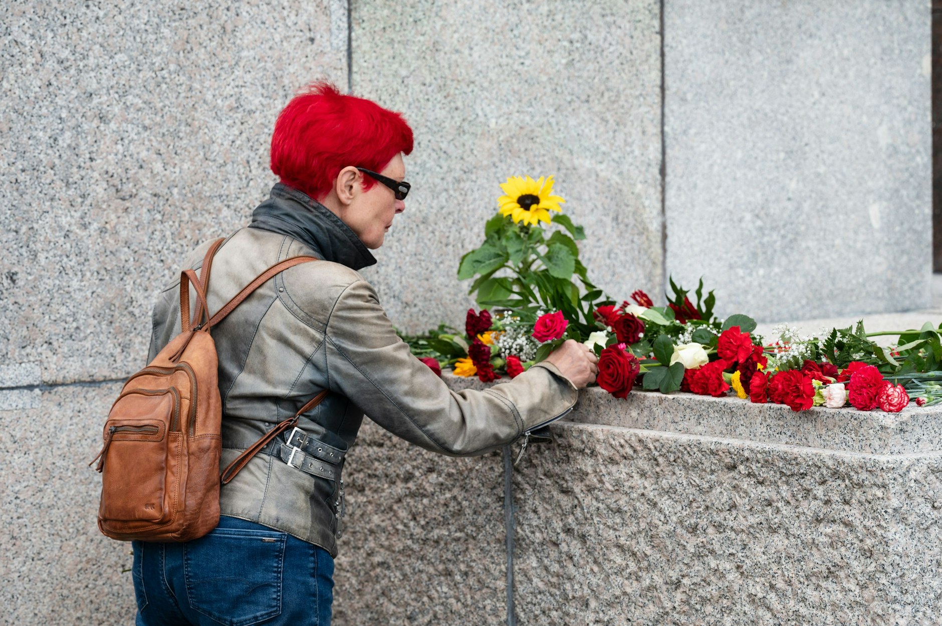 Rosen, Tulpen und Sonnenblumen werden abgelegt.