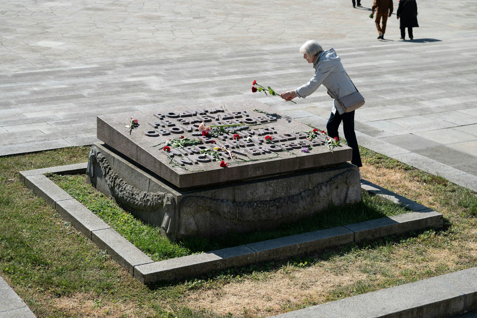 Eine Besucherin legt am Sowjetischen Ehrenmal in Treptow eine Blume nieder