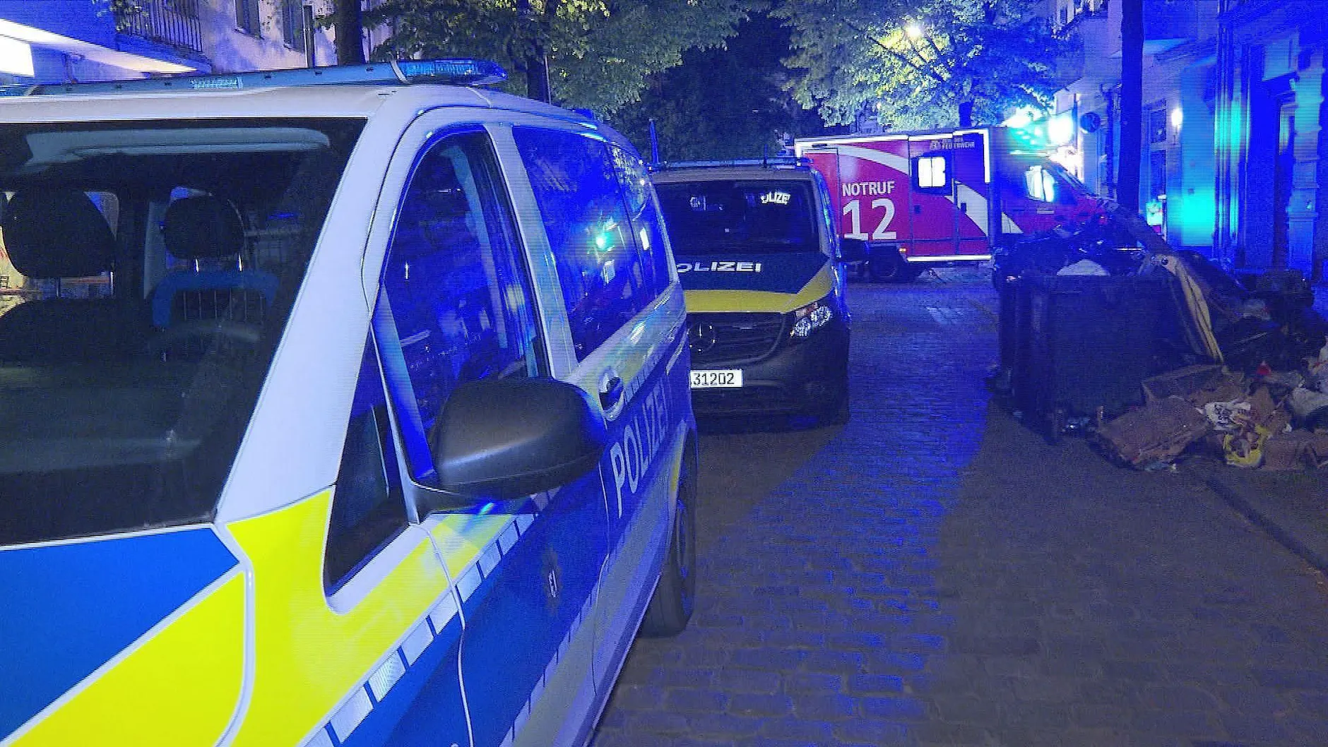 Berlin-Neukölln: Die Polizeiwagen stehen neben einem Müllberg.