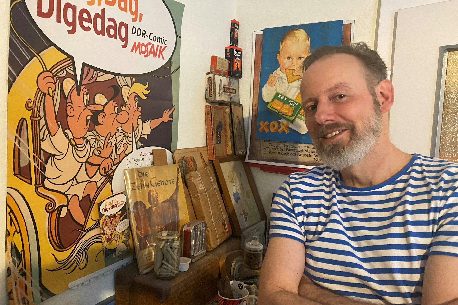 Der Berliner Comiczeichner Ulf S. Graupner (60) in seiner Wohnung vor einem Digedags-Plakat: Er zeichnete das Comeback der „Mosaik“-Helden.