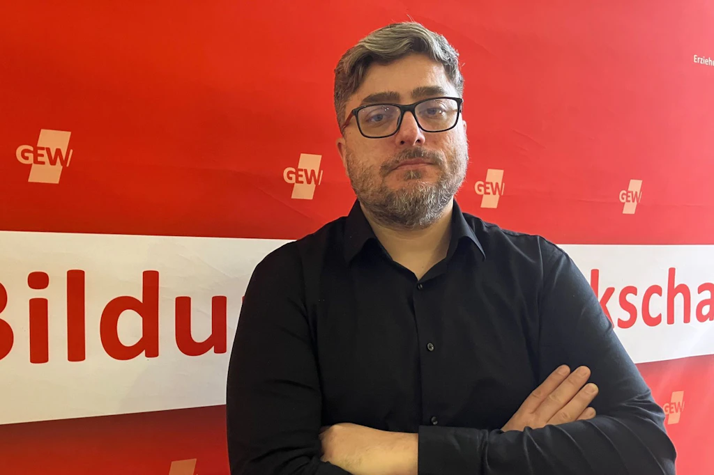 Gökhan Akgün, Landesvorsitzender der Gewerkschaft Erziehung und Wissenschaft (GEW), steht in einem Raum in der Geschäftsstelle der GEW.