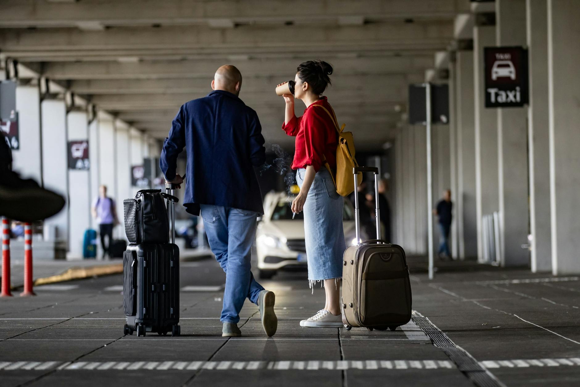 Reisende warten auf ein Taxi am Flughafen BER.