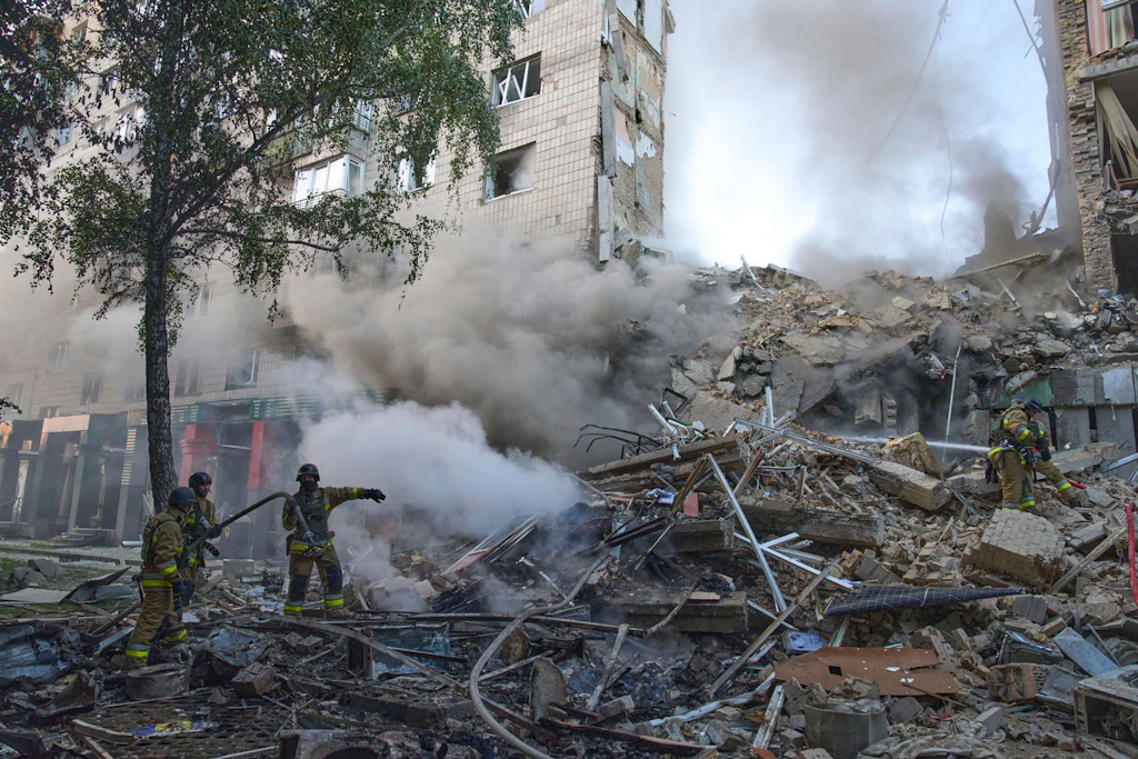 Feuerwehrleute löschen einen Brand nach dem Einschlag einer Rakete in ein Wohnhaus während eines massiven russischen Raketen- und Drohnenangriffs in Kiew.