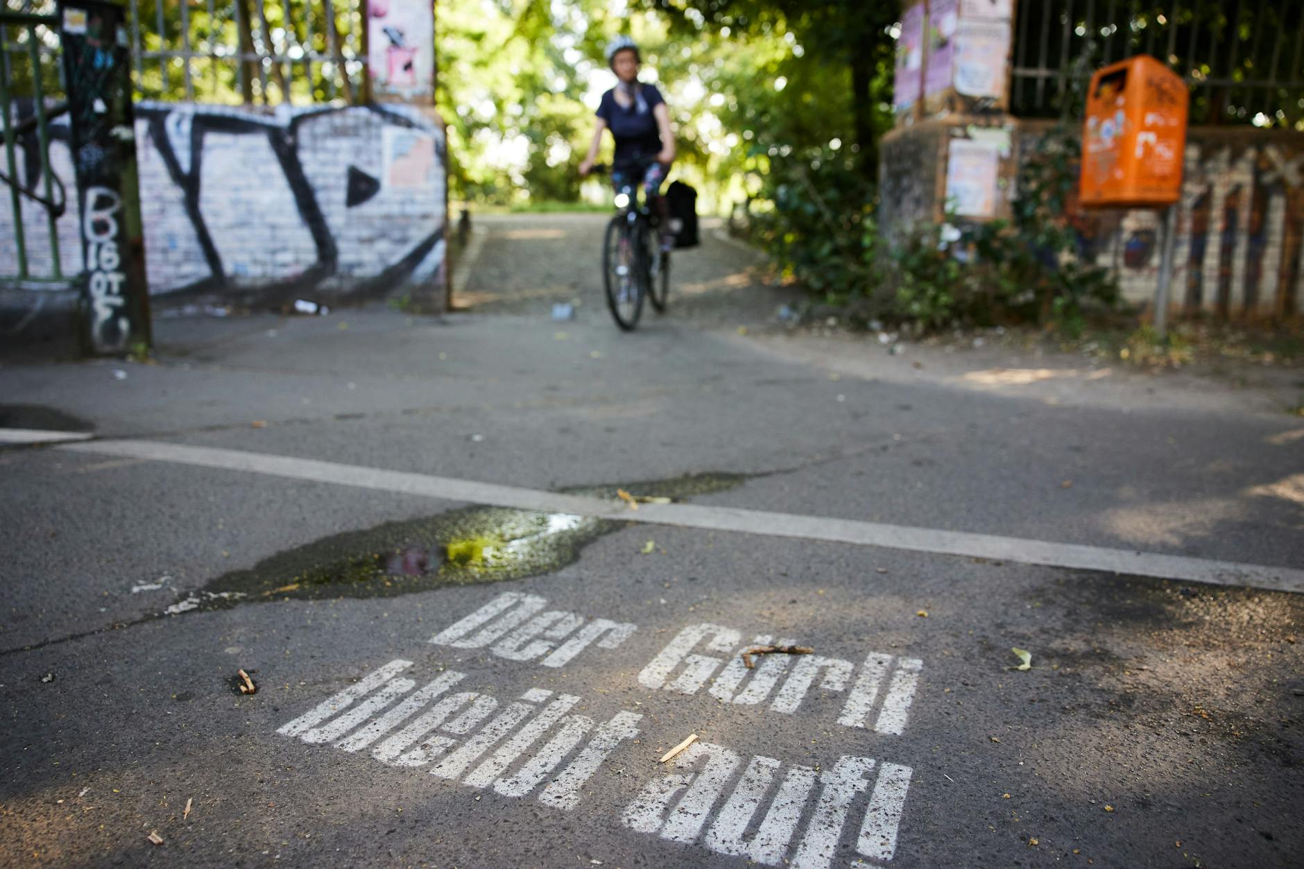 „Der Görli bleibt auf!“ steht auf einem Weg am Eingang zum Görlitzer Park.