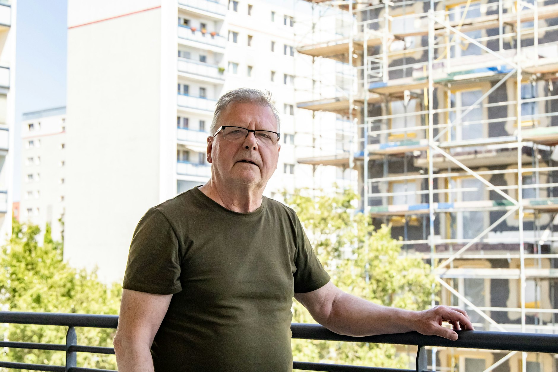 Axel Matthies auf seinem Balkon am U-Bahnhof Kaulsdorf Nord, rechts der Rohbau